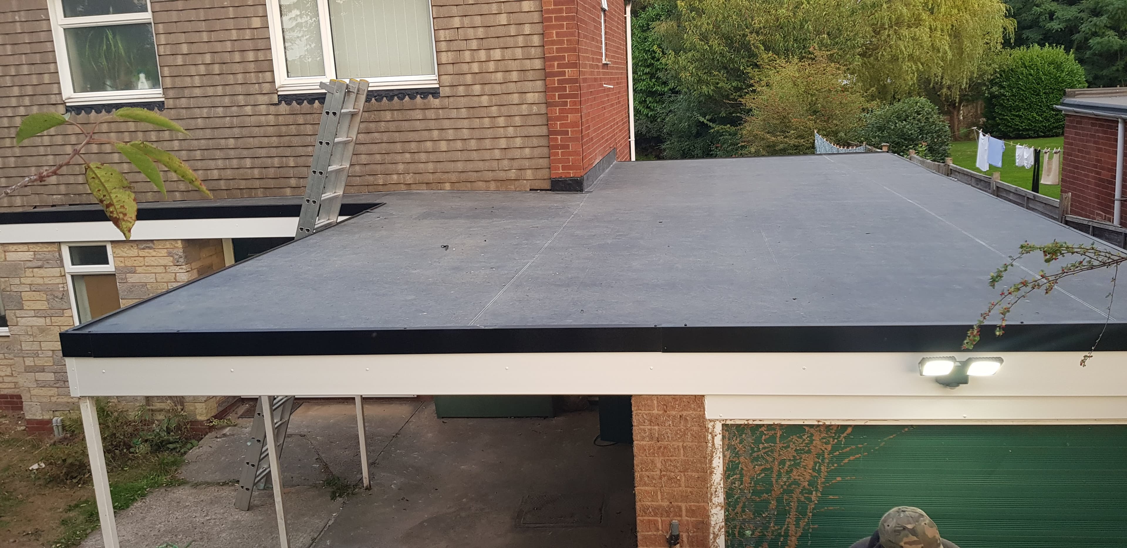 Grey flat roof with black fascia trim on residential extension