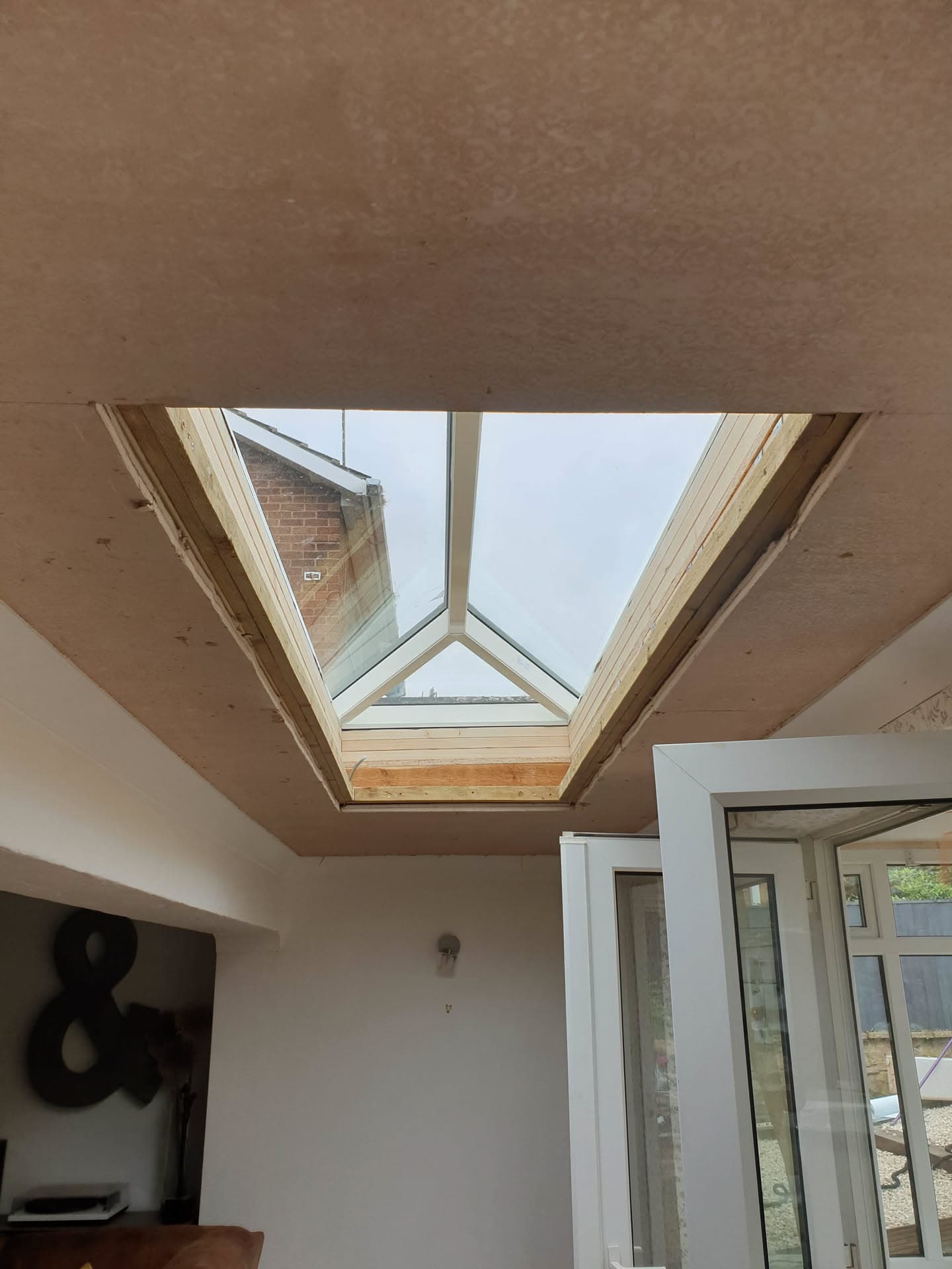 Interior view of timber-framed roof lantern with glazed panels in white ceiling