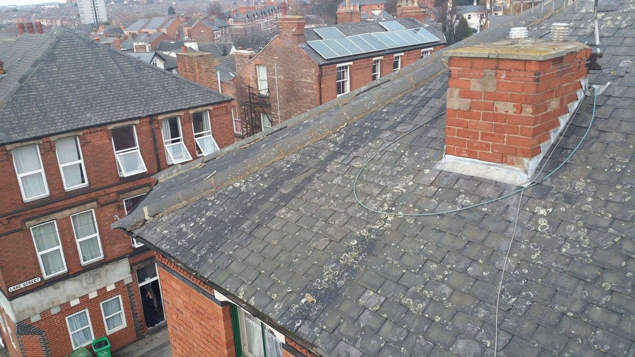 Pitched slate roof with brick chimney stack on terraced house