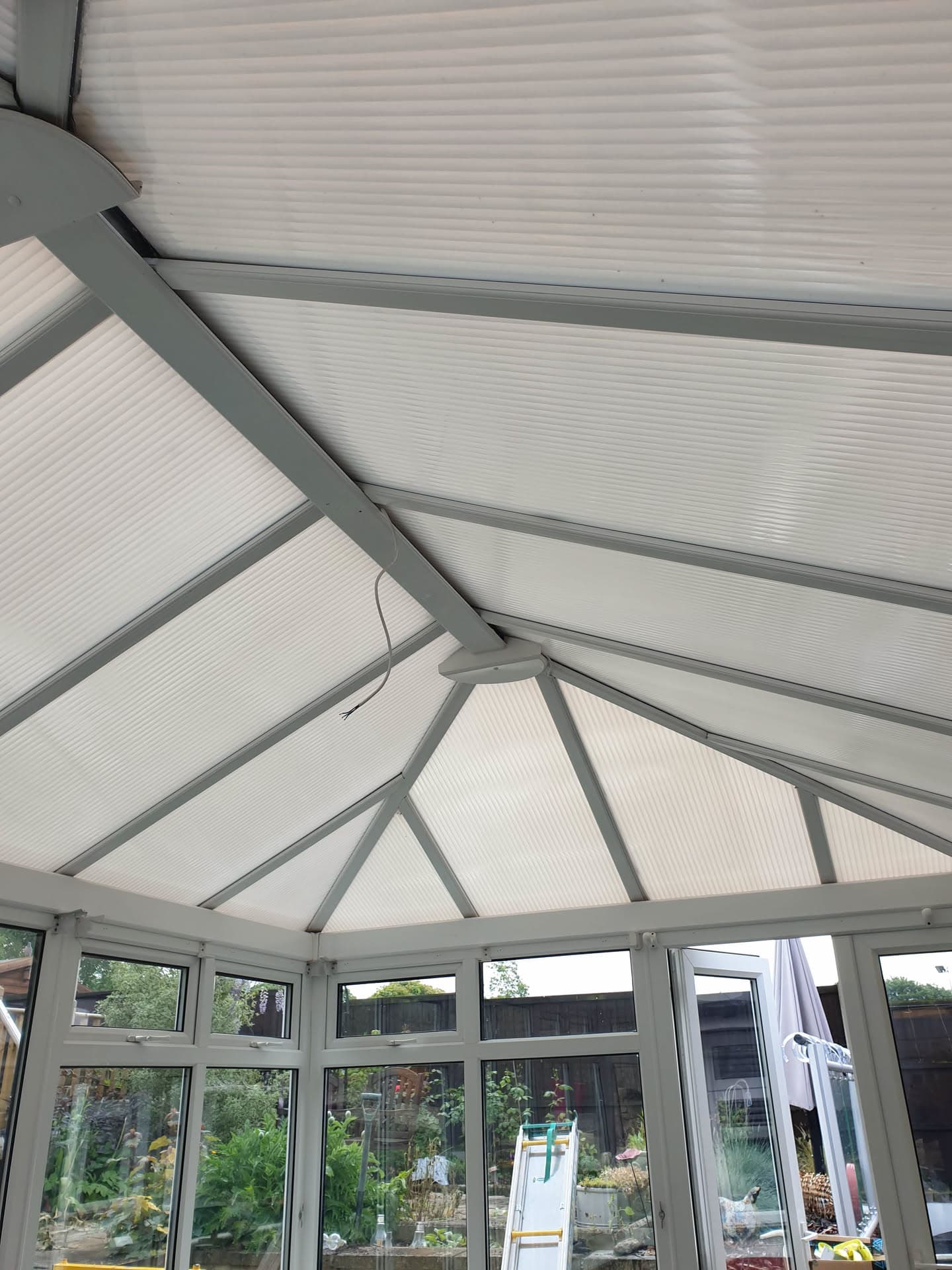 Conservatory roof with white polycarbonate panels and grey aluminium glazing bars