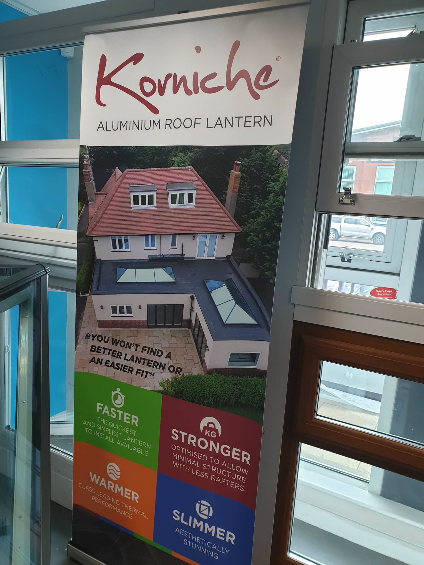 Korniche aluminium roof lantern promotional banner showing house with red tiled pitched roof and flat roof extension with roof lanterns
