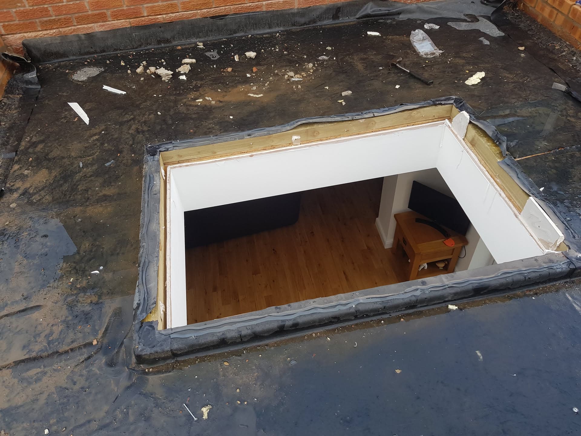 Flat roof with skylight opening showing timber frame and lead flashing detail
