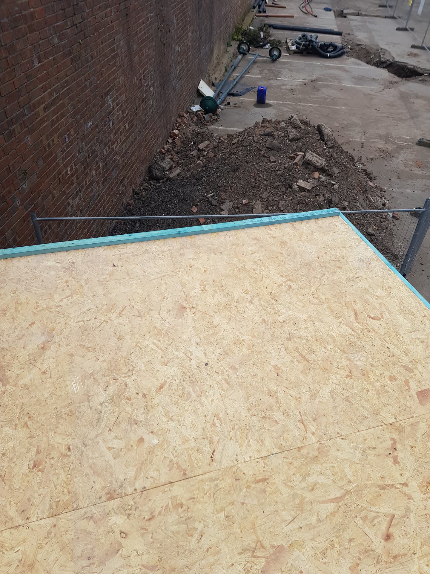 Flat roof with OSB decking and turquoise trim during construction