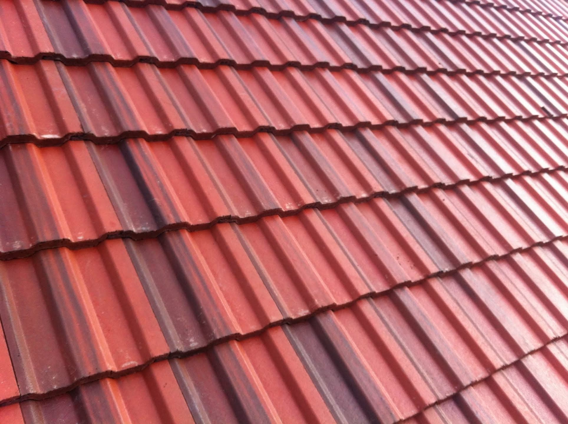 Pitched roof with red concrete interlocking tiles in overlapping rows
