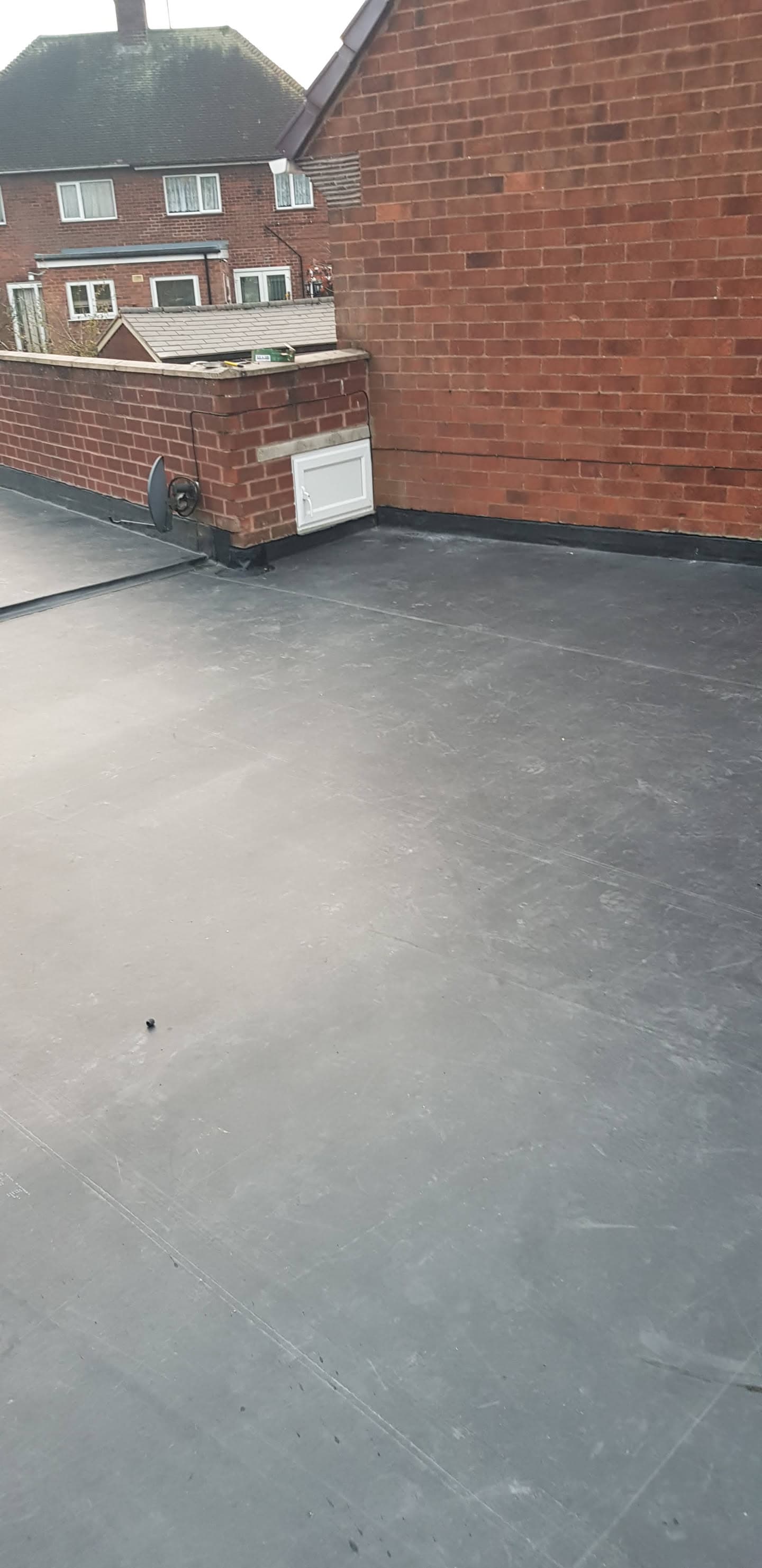 Completed flat roof with grey EPDM rubber membrane on residential extension
