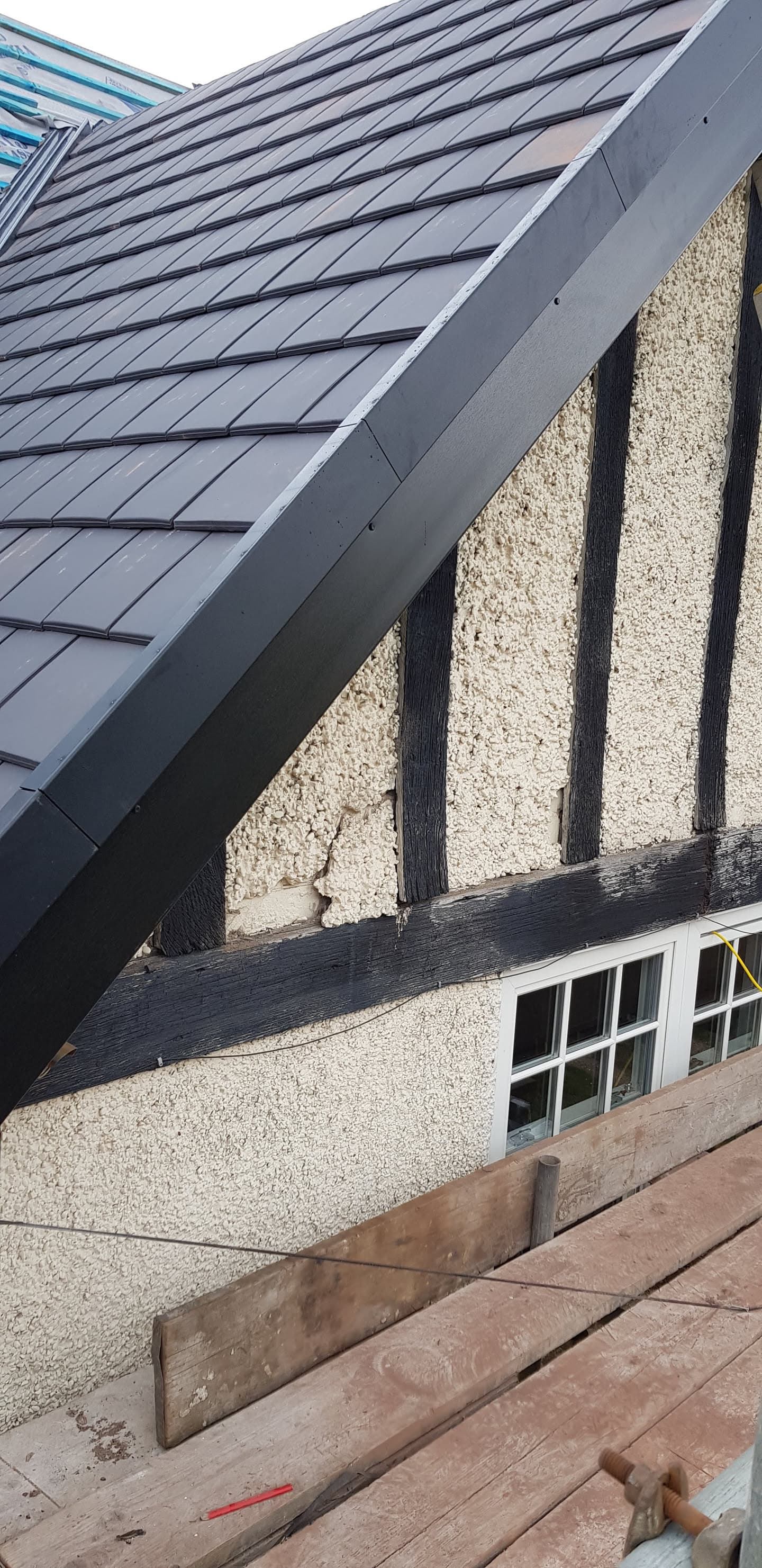 Pitched roof with dark grey slate tiles and matching fascia boards