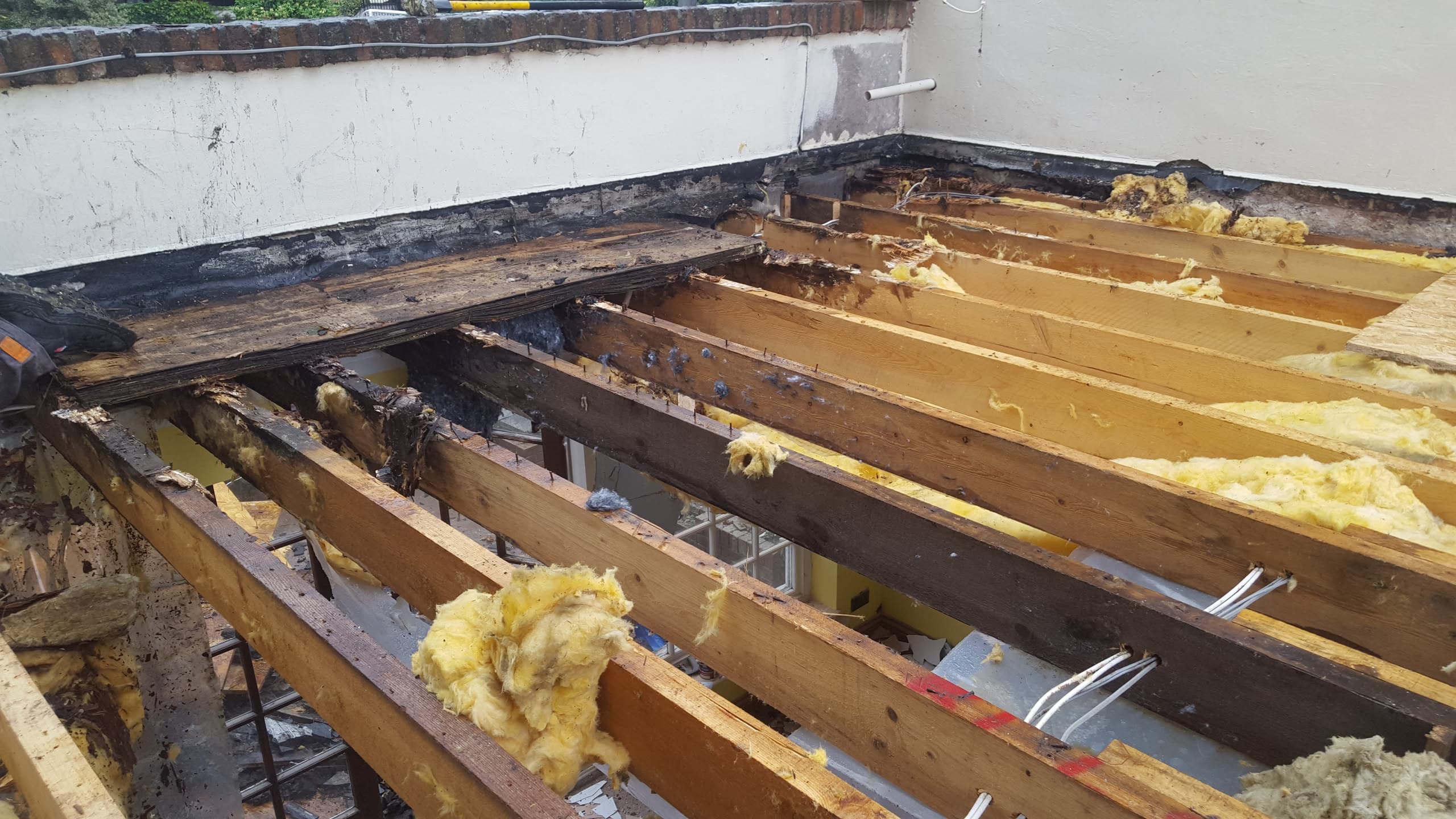 Flat roof stripped back to timber joists with old felt and insulation removed