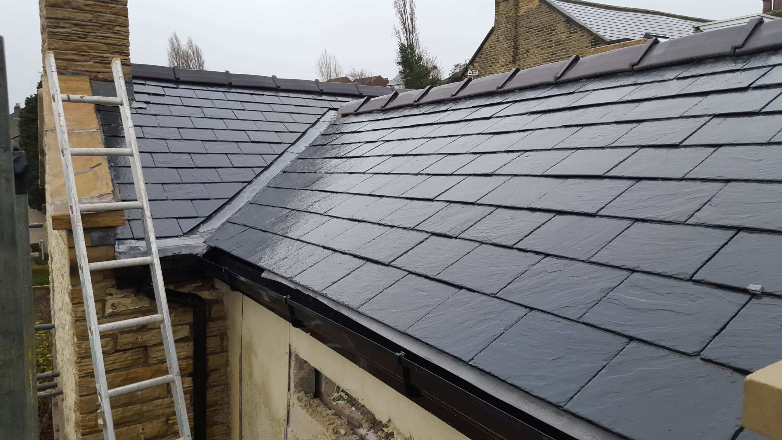 New pitched slate roof with dark grey slates and black fascias