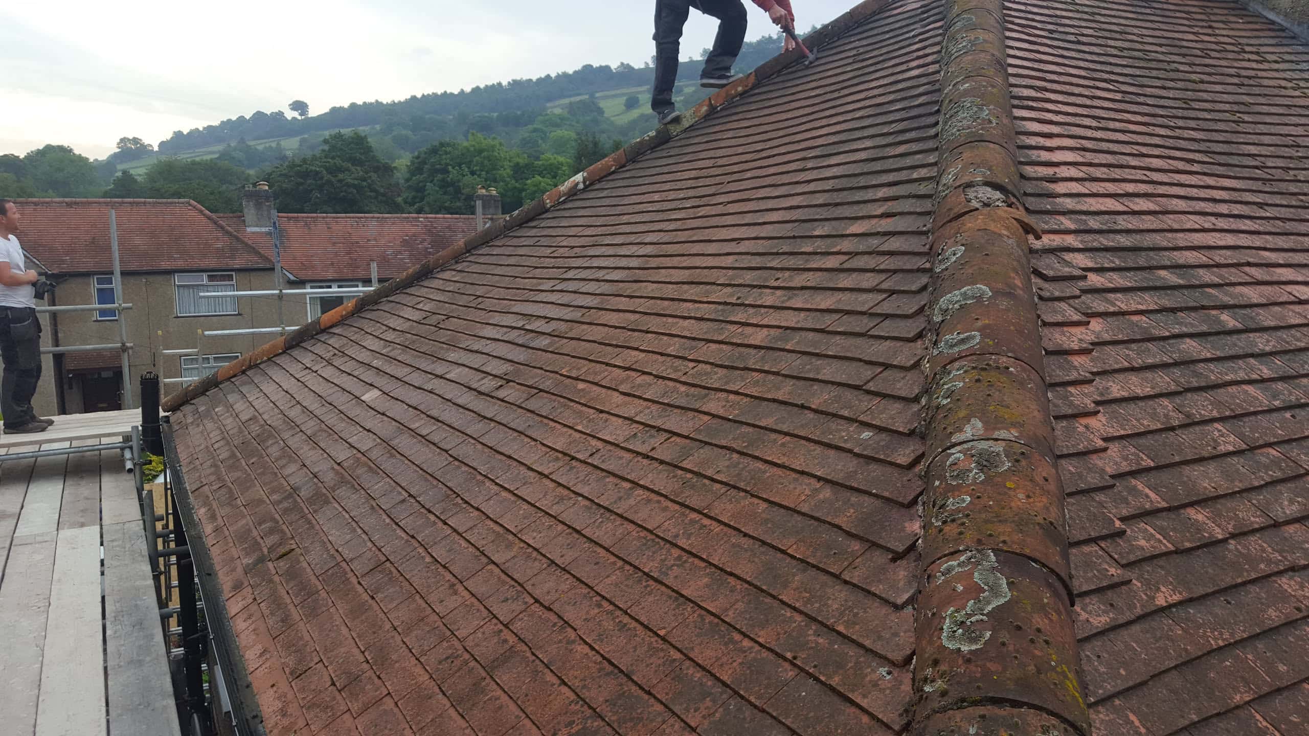 WeatherTech roofer working on a pitched concrete tiled roof with weathered ridge tiles