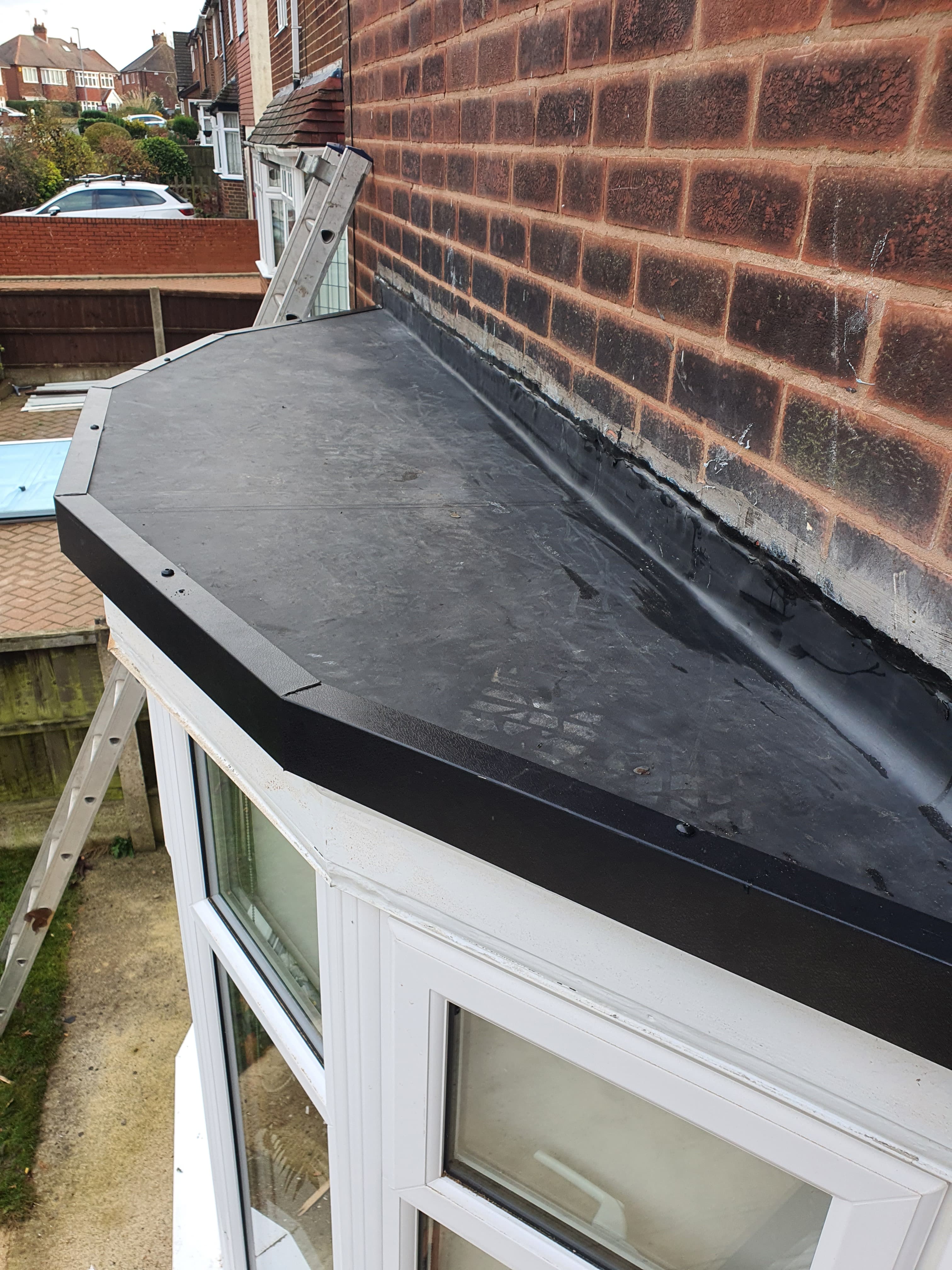 Flat roof extension with black EPDM rubber membrane and white fascia trim