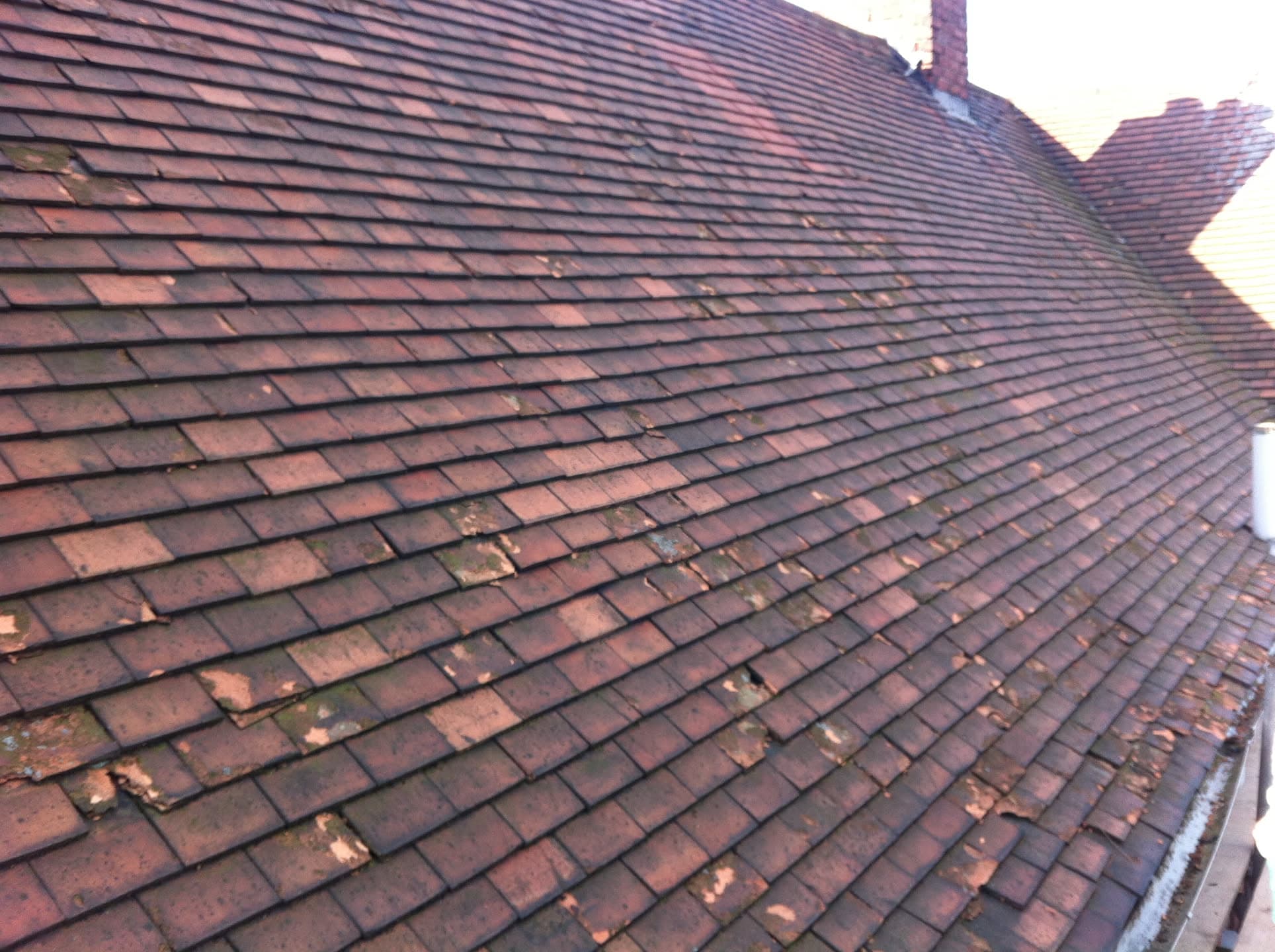 Pitched roof with red clay tiles and brick chimney stack