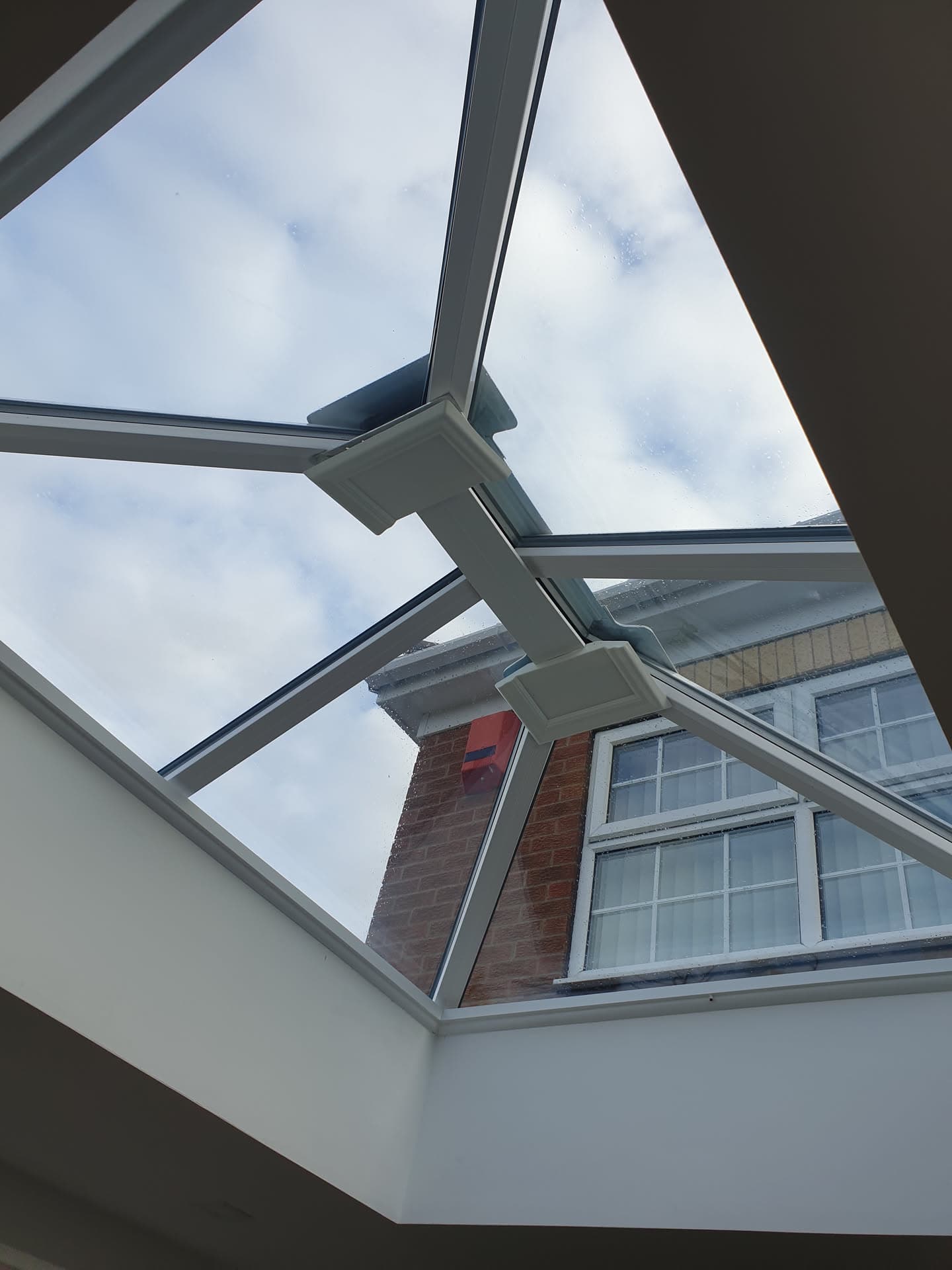 Glass conservatory roof with anthracite aluminium framework and white fascias