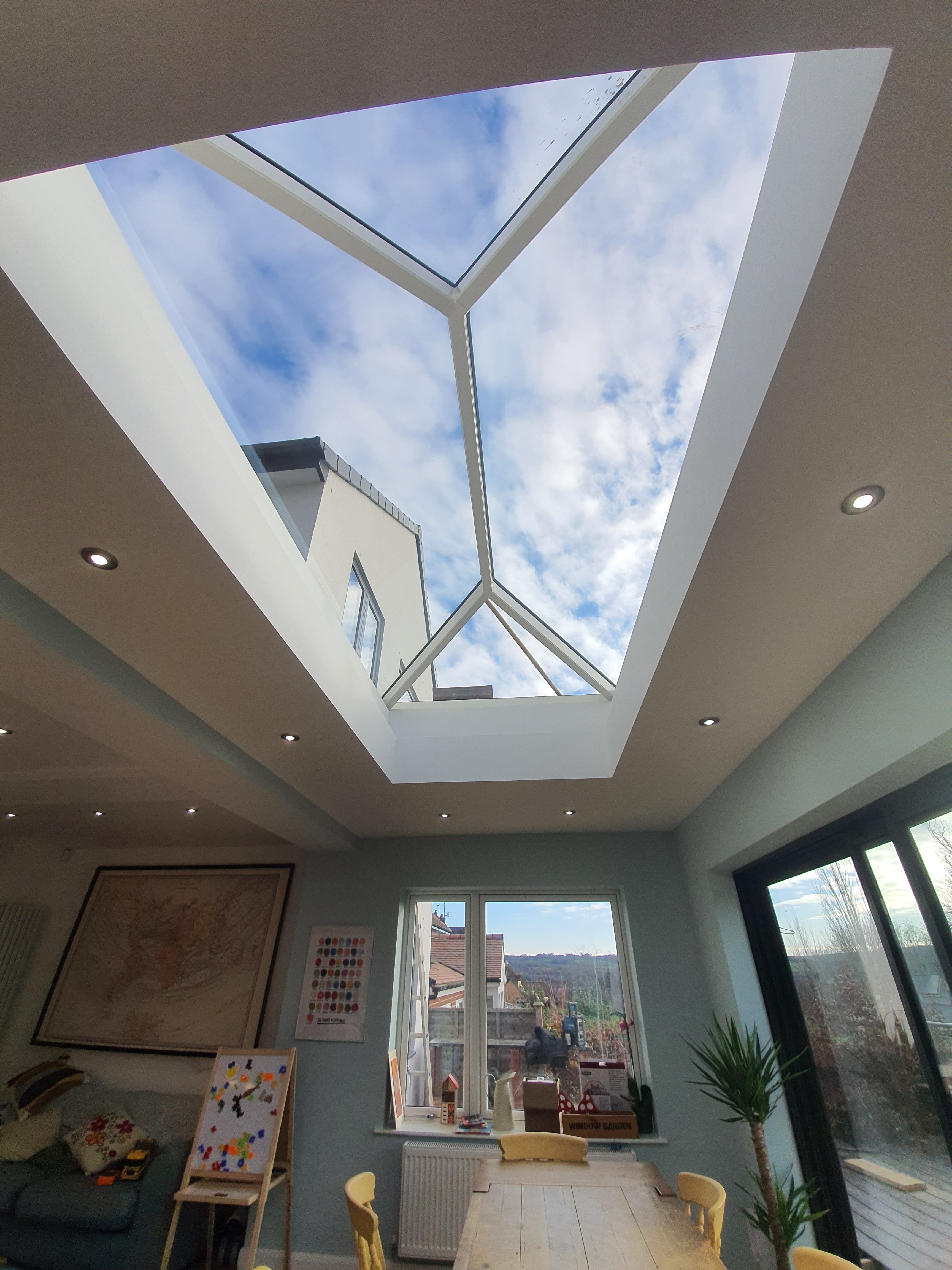 Large roof lantern skylight with white frame installed in residential extension ceiling