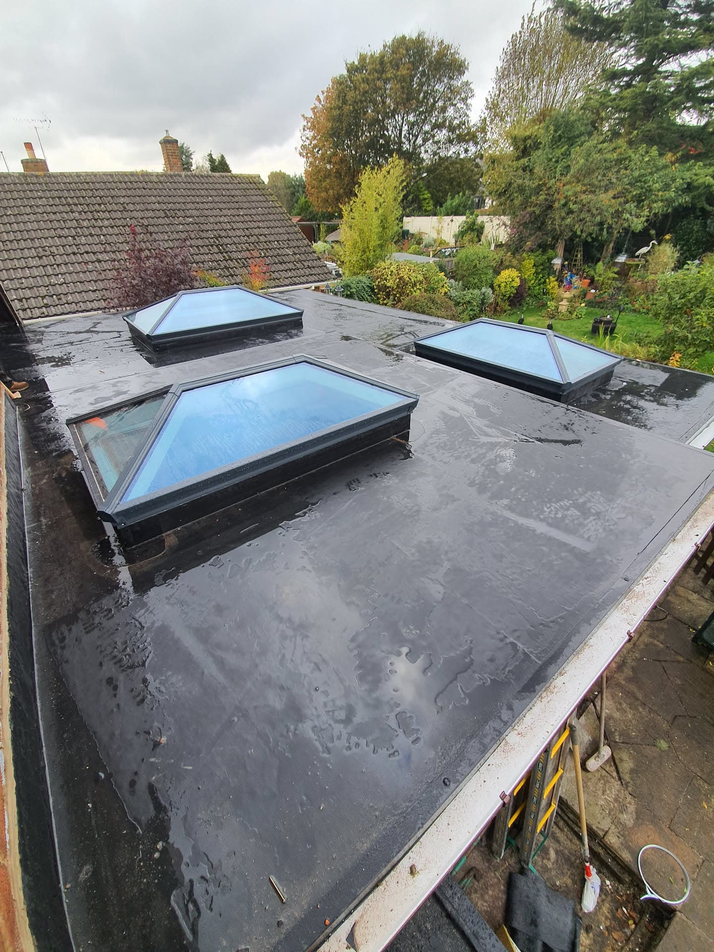 Flat roof with GRP fibreglass finish and three roof lanterns with black frames