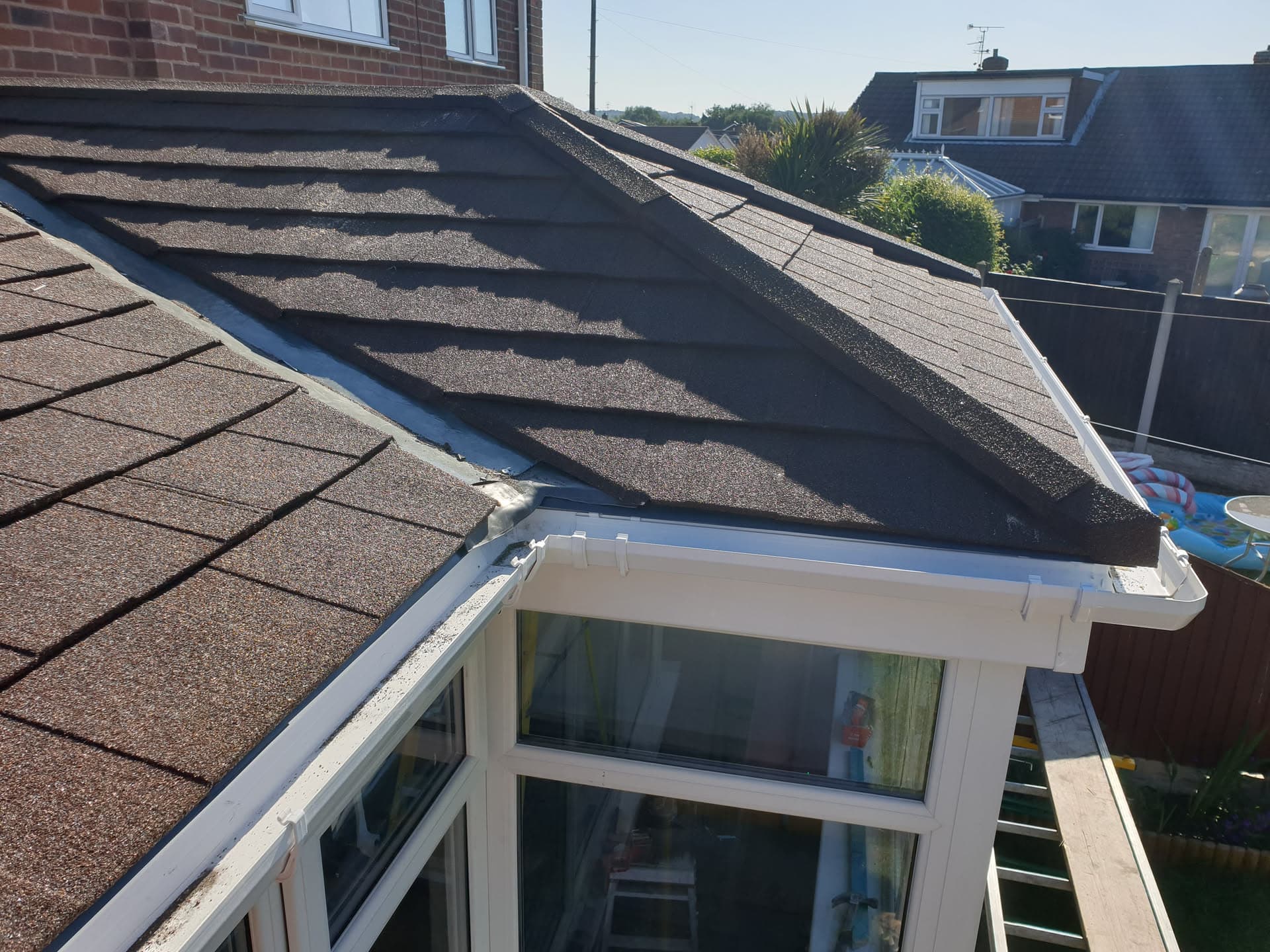 Pitched roof with brown concrete tiles and white fascias and guttering