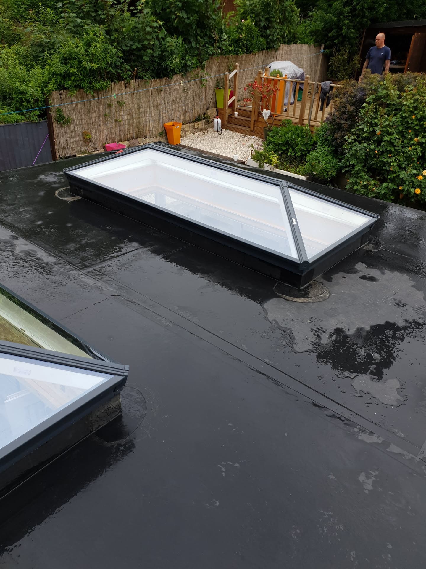 Flat roof with two rectangular rooflights installed on dark GRP surface