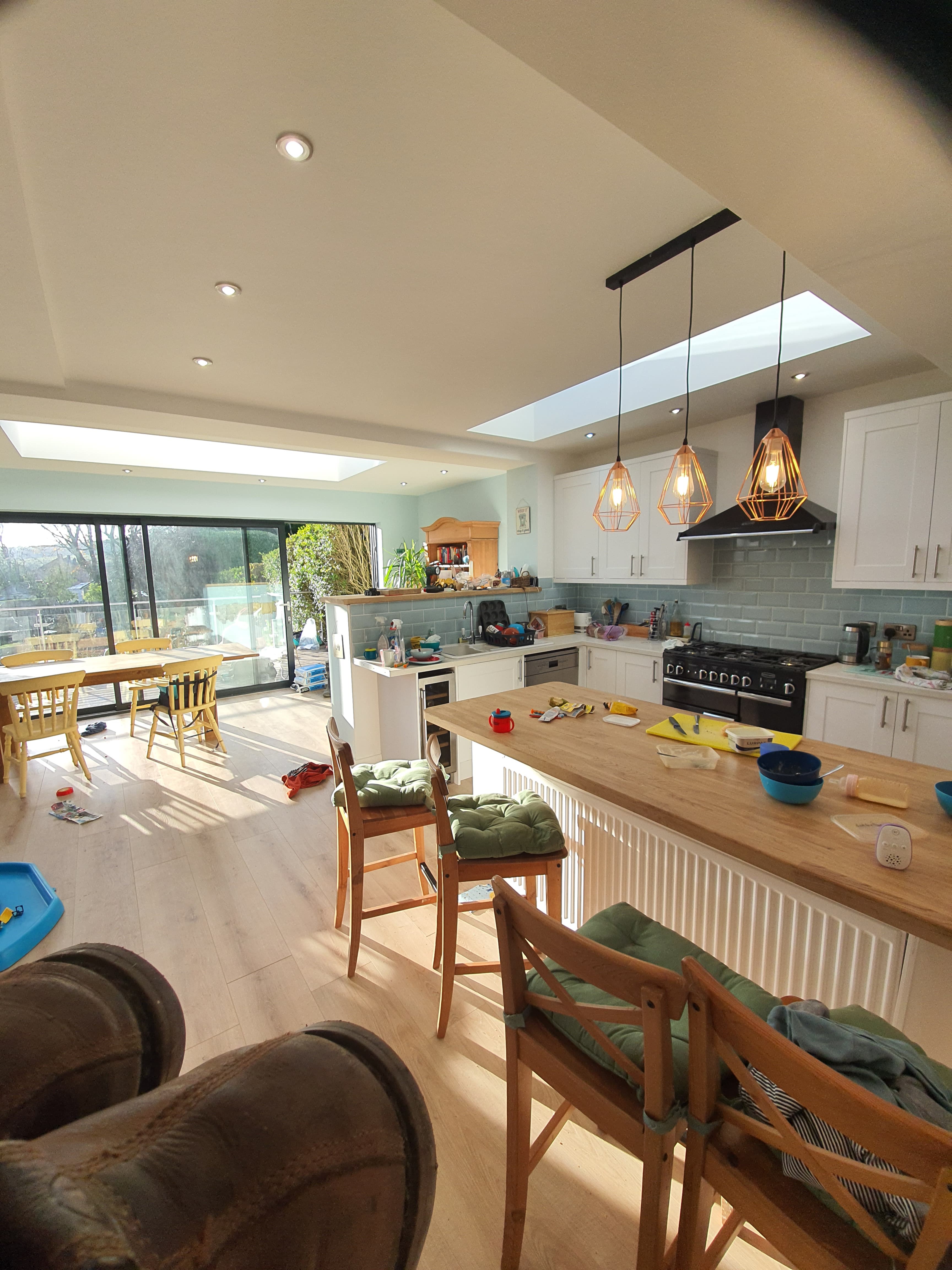 Kitchen extension with flat roof and multiple skylights allowing natural light
