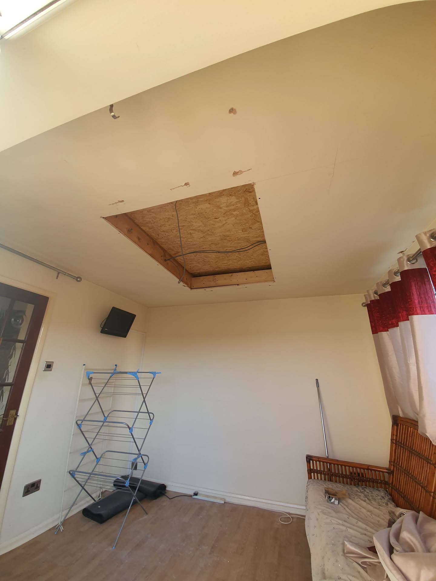 Interior ceiling damage with exposed roof boarding requiring flat roof repair