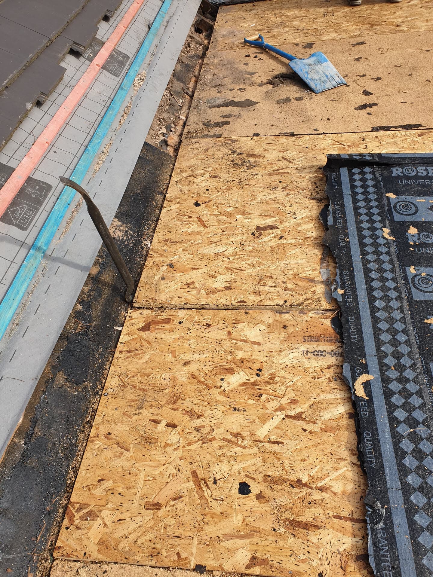 Flat roof decking boards being installed with breathable membrane and fascia visible