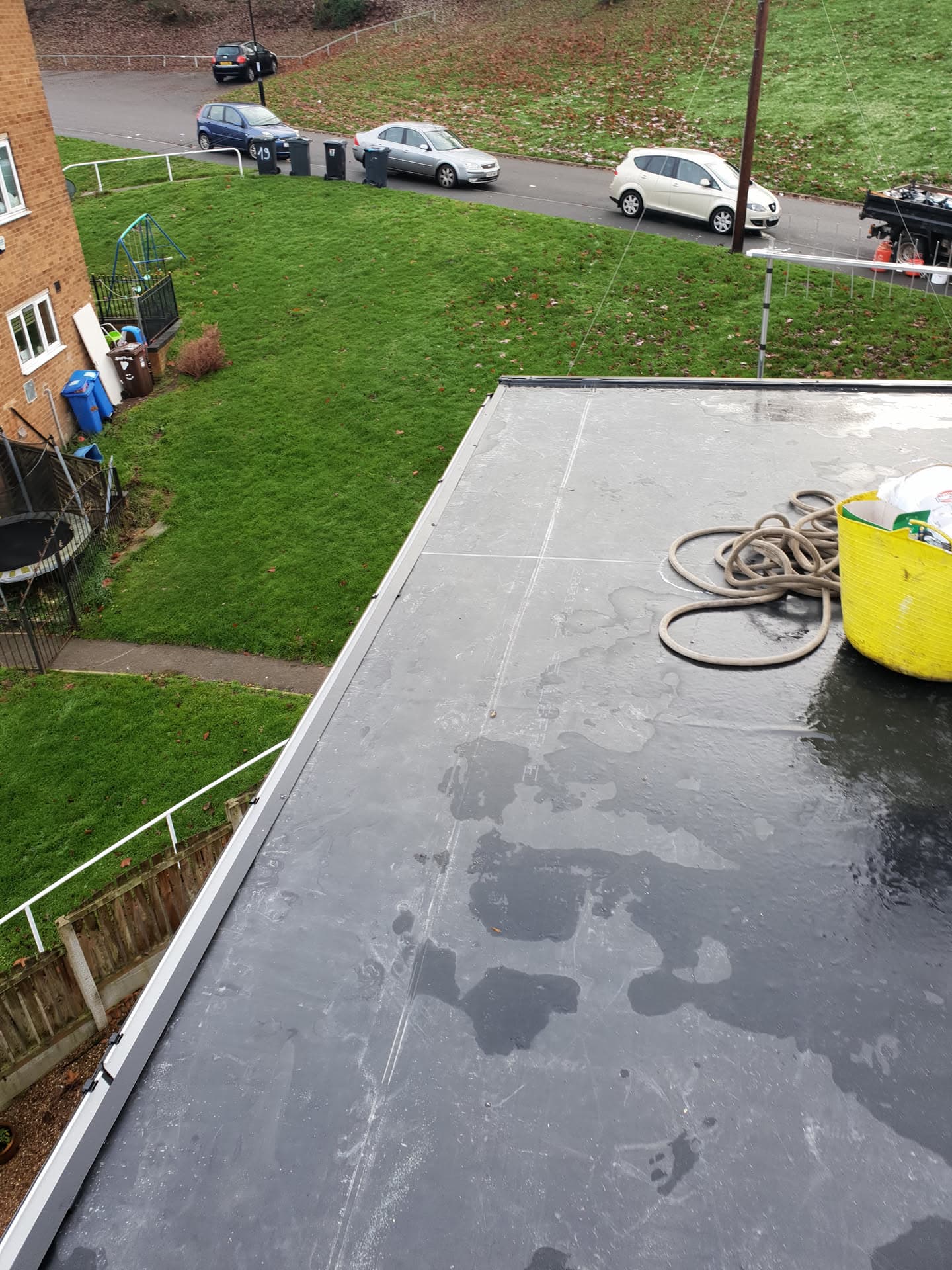 Grey GRP flat roof on residential extension with white fascia trim