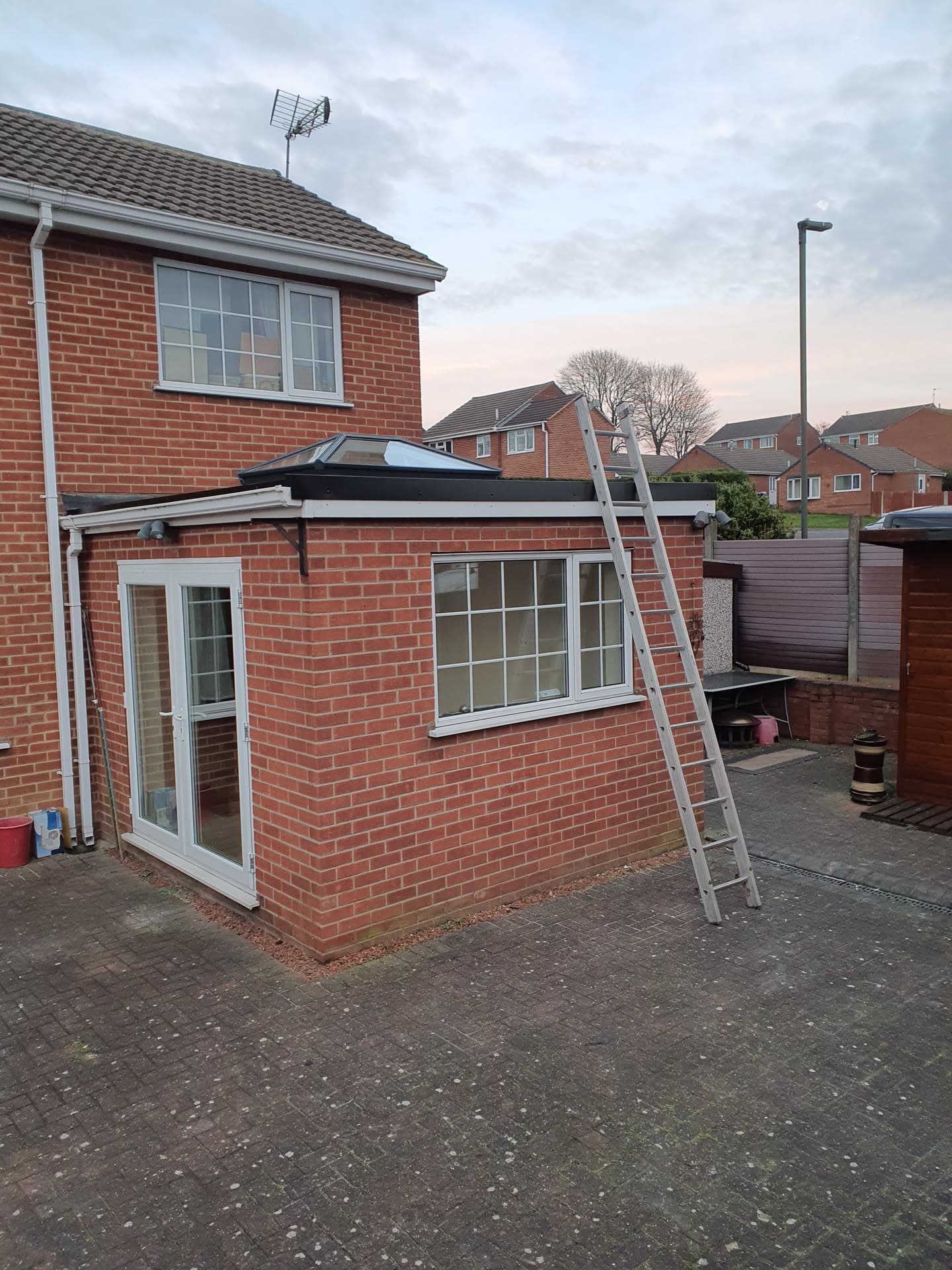 Flat roof extension with dark grey GRP fibreglass finish and white fascias