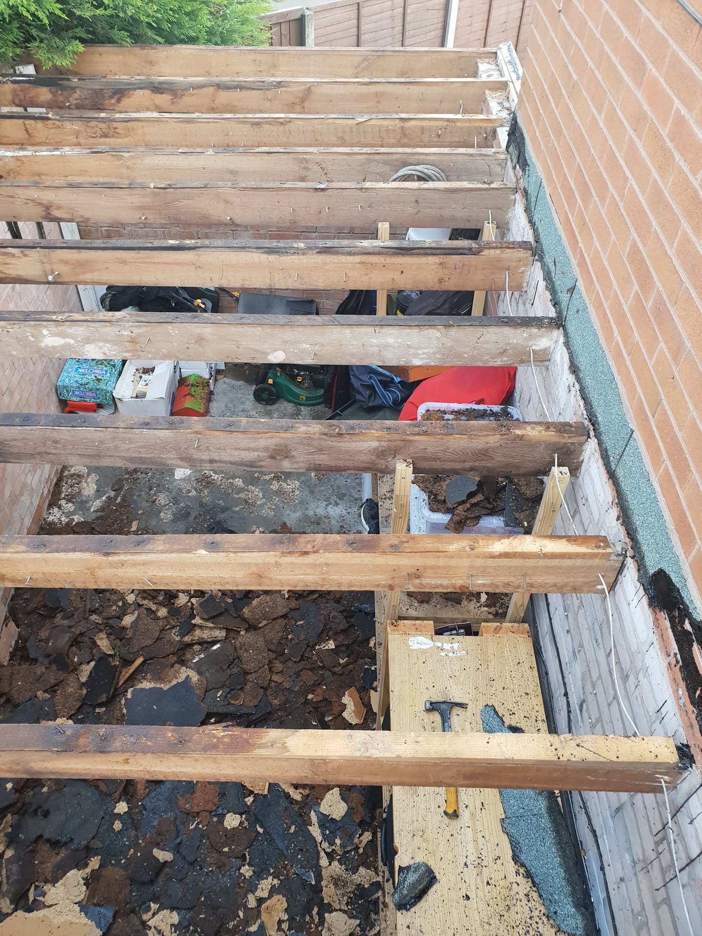 Exposed timber joists of flat roof during replacement with old felt removed