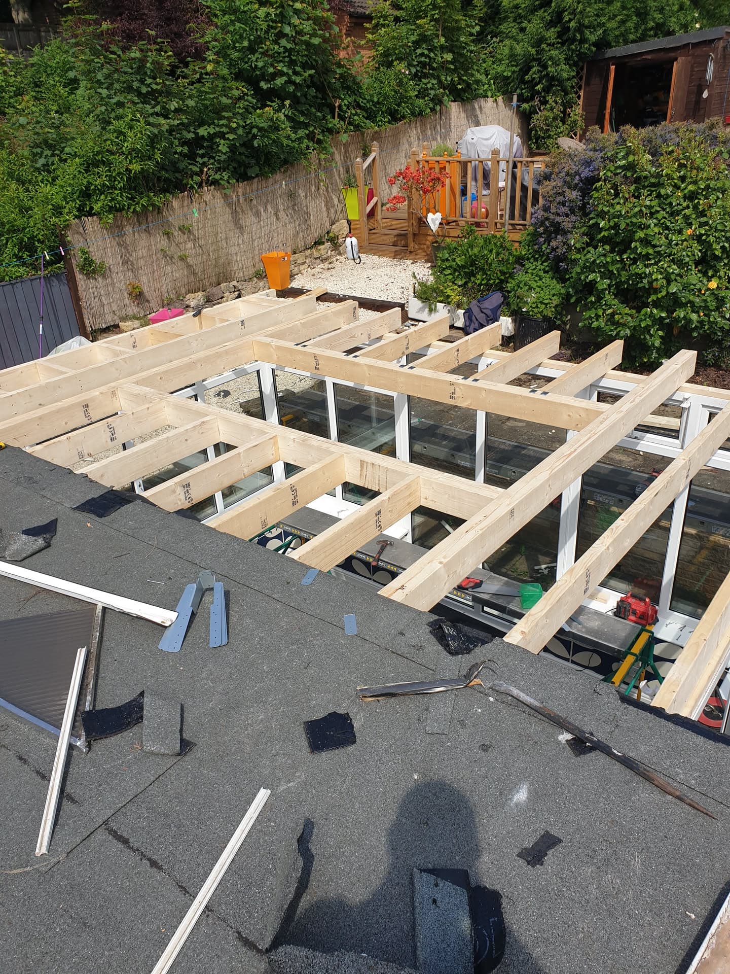 Timber frame construction in progress for a flat roof extension over existing felt roof