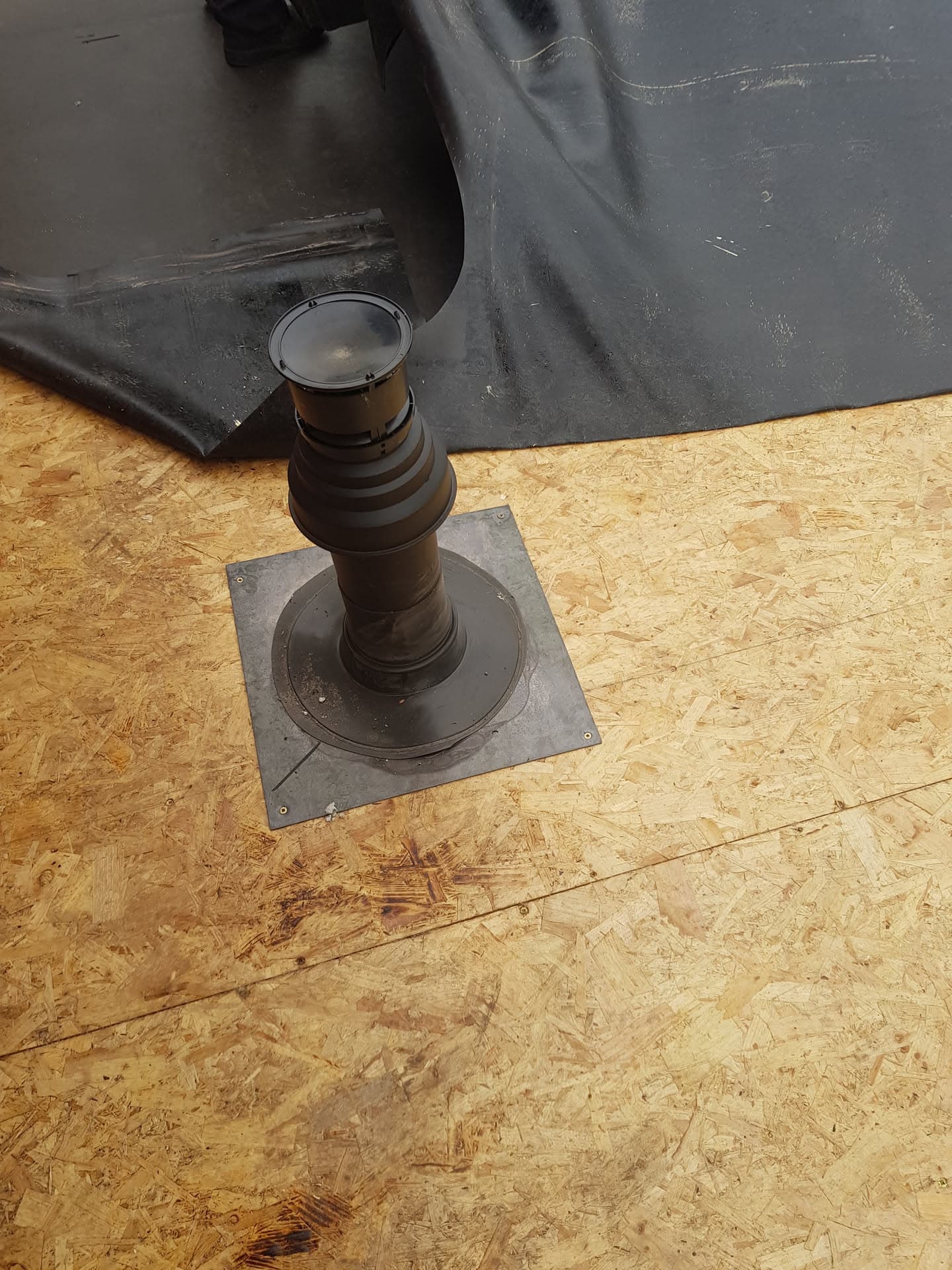 Rubber roof vent pipe boot installed on flat roof with EPDM membrane
