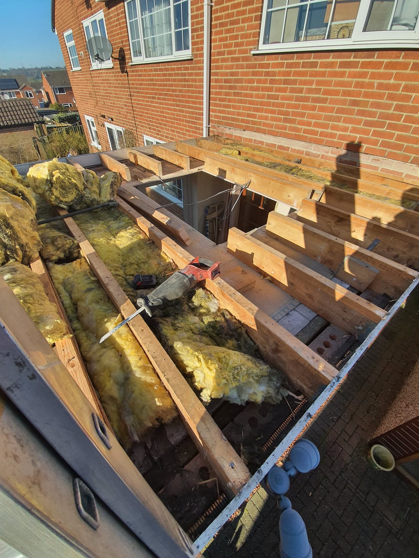 Flat roof extension stripped back to timber joists with exposed insulation during renovation