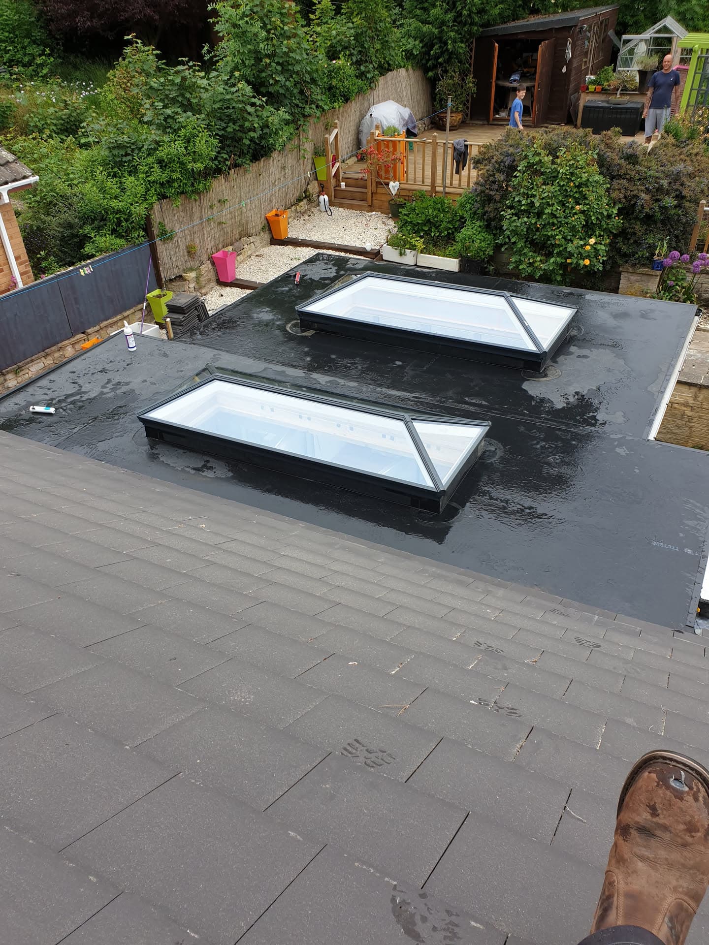 Flat roof with two rectangular rooflights and dark felt covering on residential extension