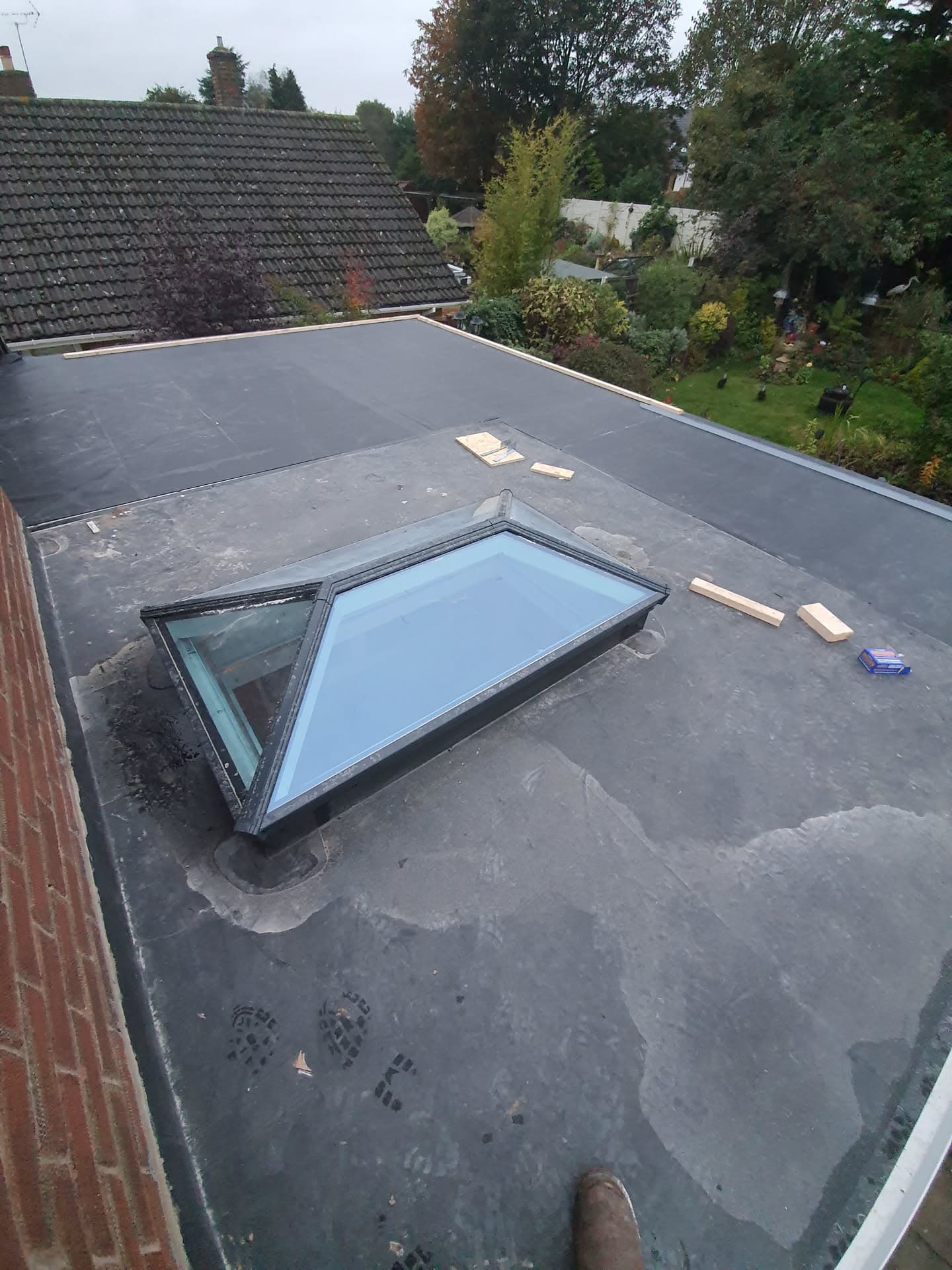 Grey EPDM flat roof with lantern skylight on residential extension