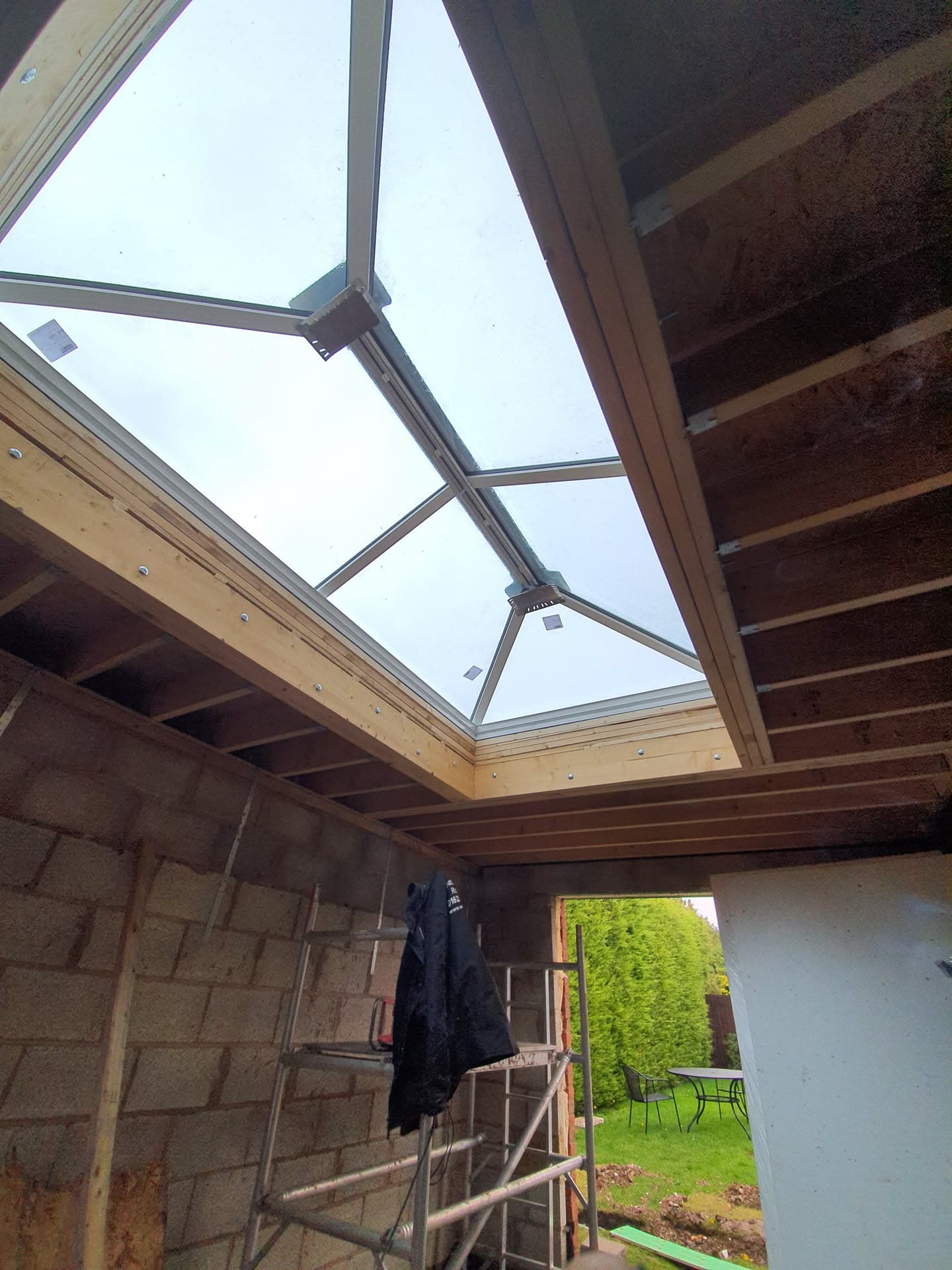 Glass conservatory roof with aluminium framework viewed from inside during construction