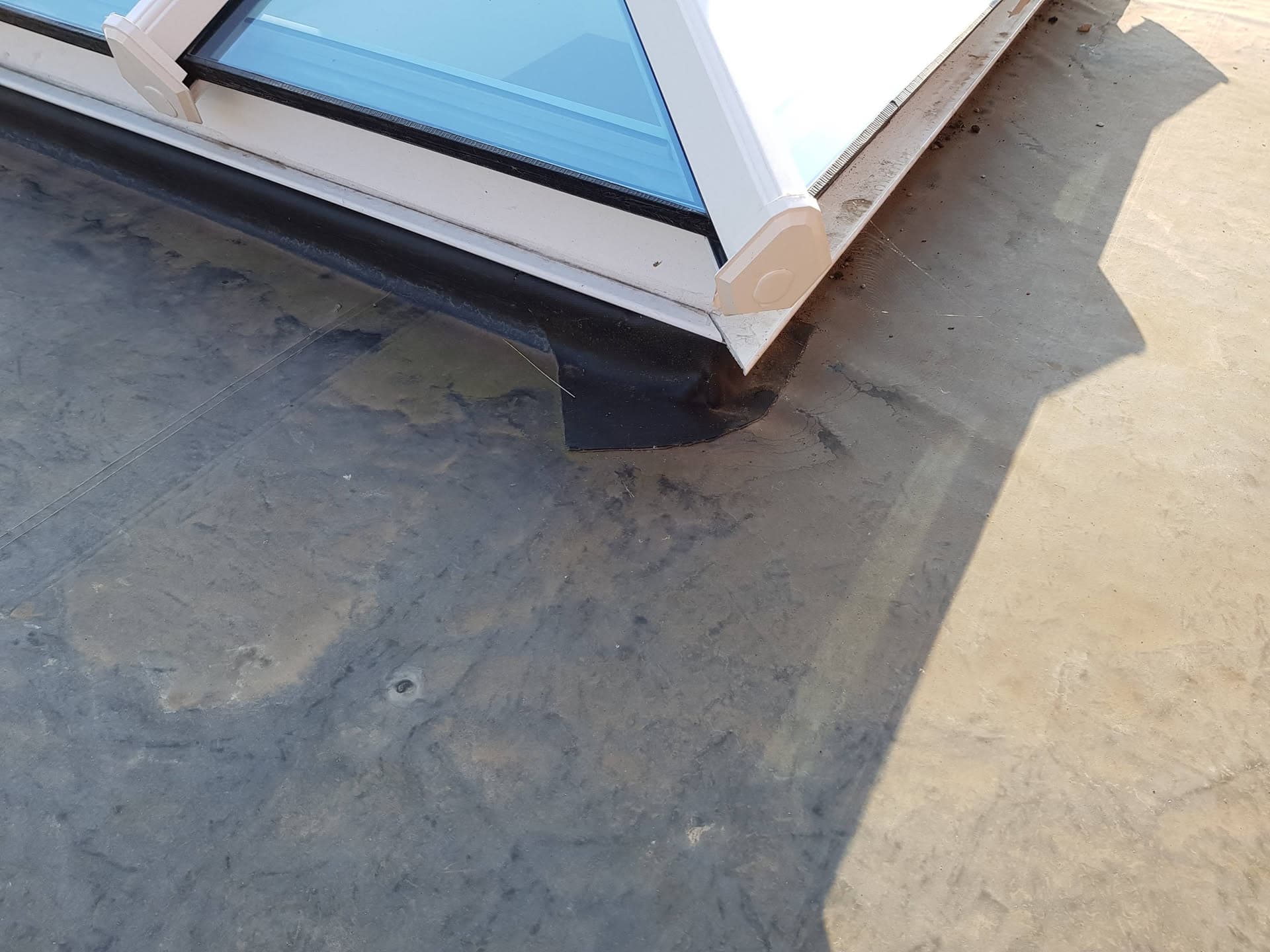 Flat roof with GRP fibreglass surface and skylight with white trim and lead flashing