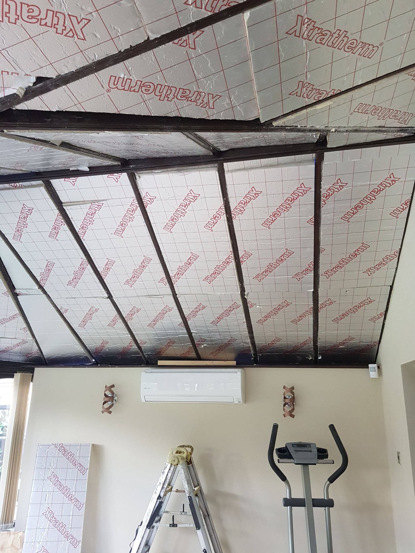 Conservatory roof under construction with dark metal glazing bars and breathable membrane