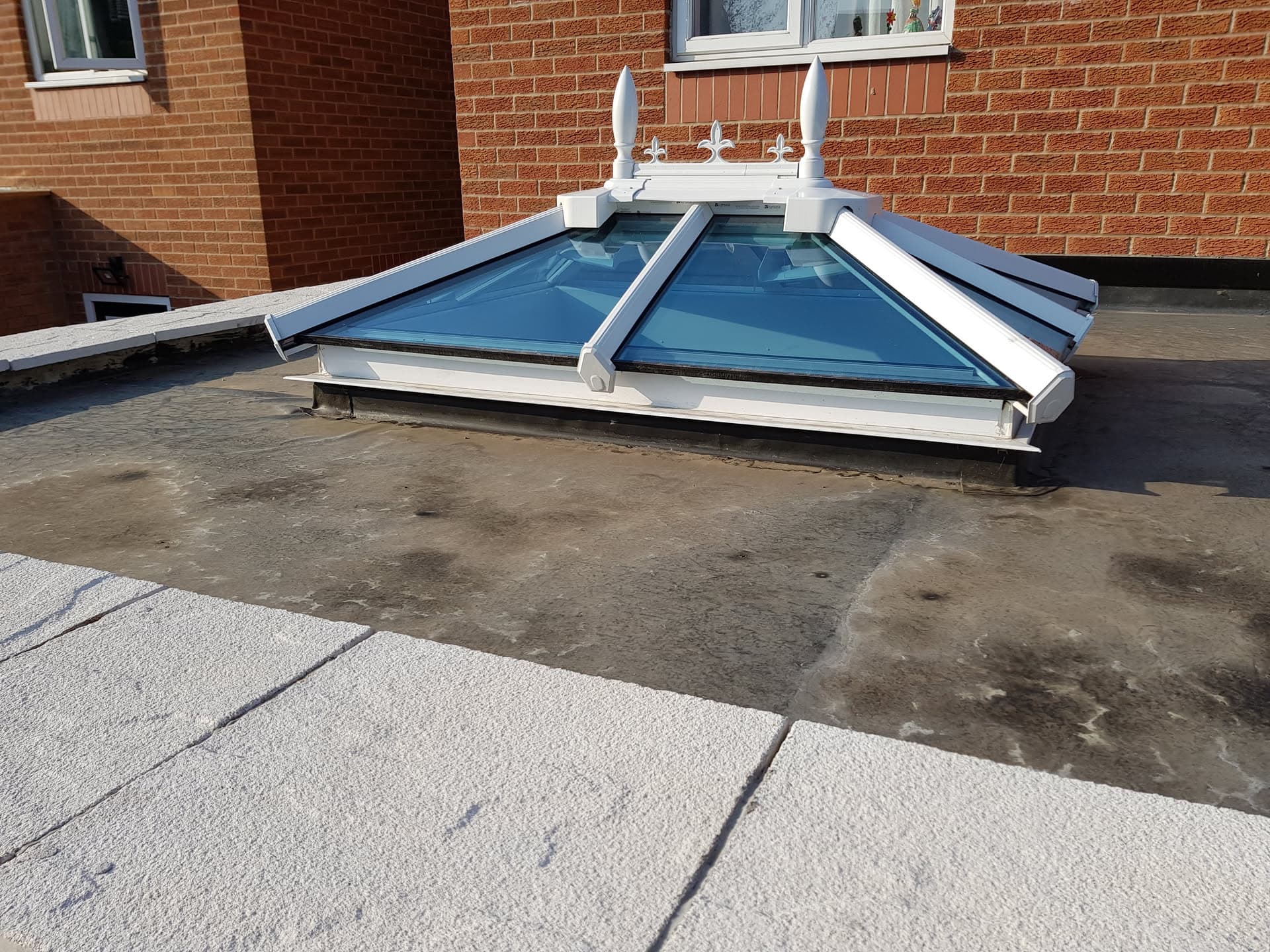 Flat roof with white-framed roof lantern featuring blue glazing panels and decorative finials
