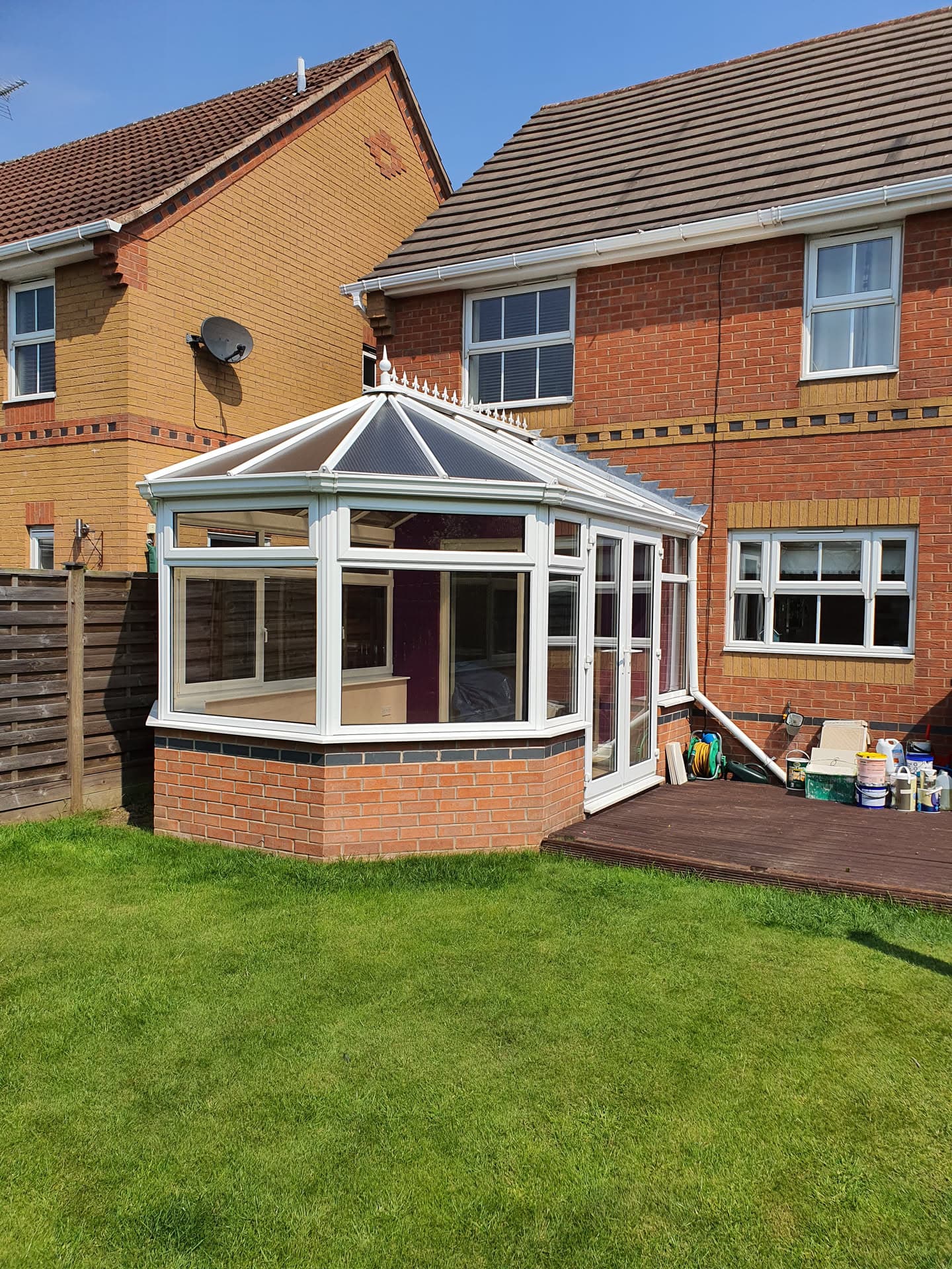 White uPVC conservatory with grey polycarbonate roof on brick-built residential property