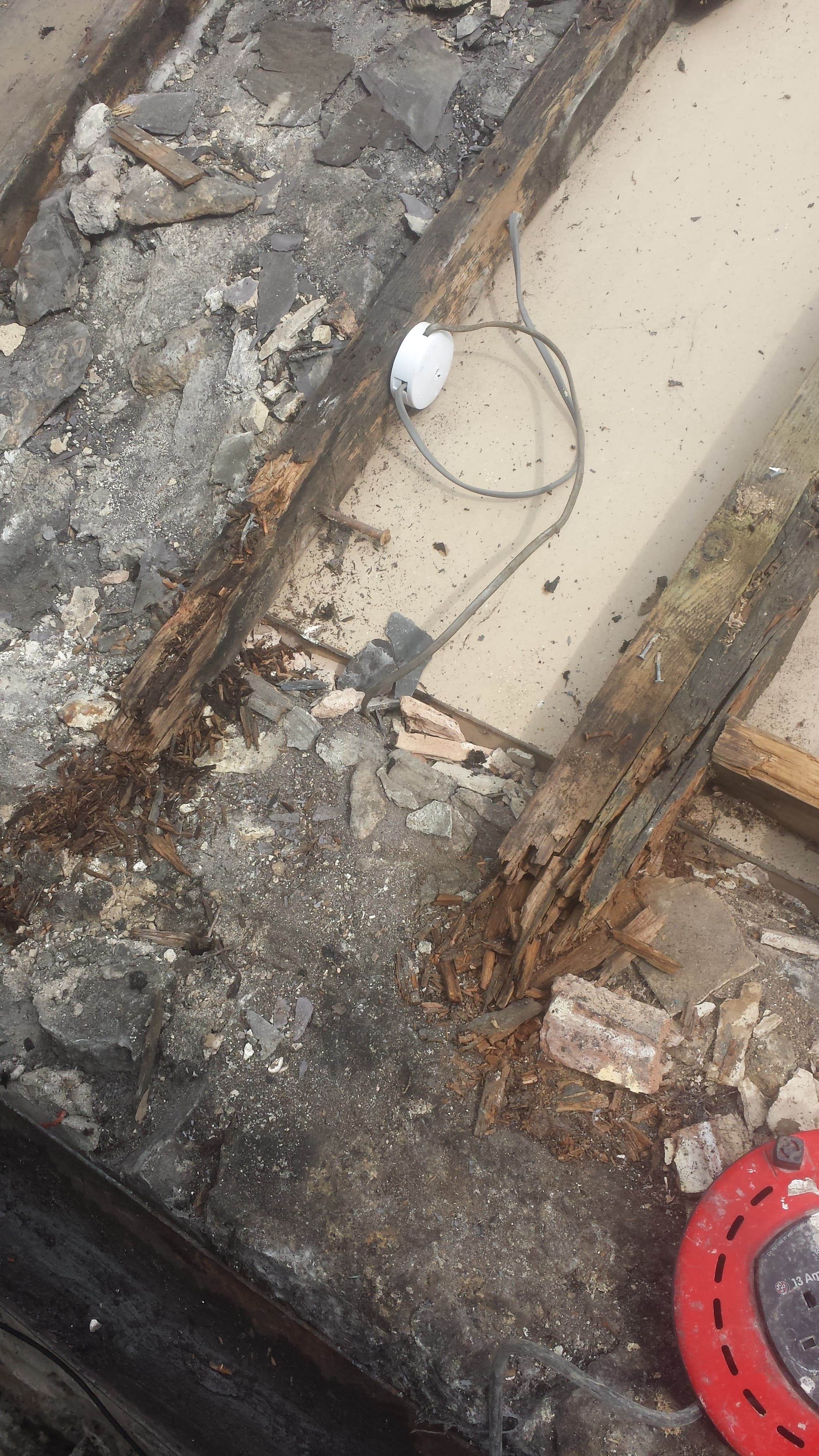 Damaged flat roof with deteriorated timber joists and old roofing material removed