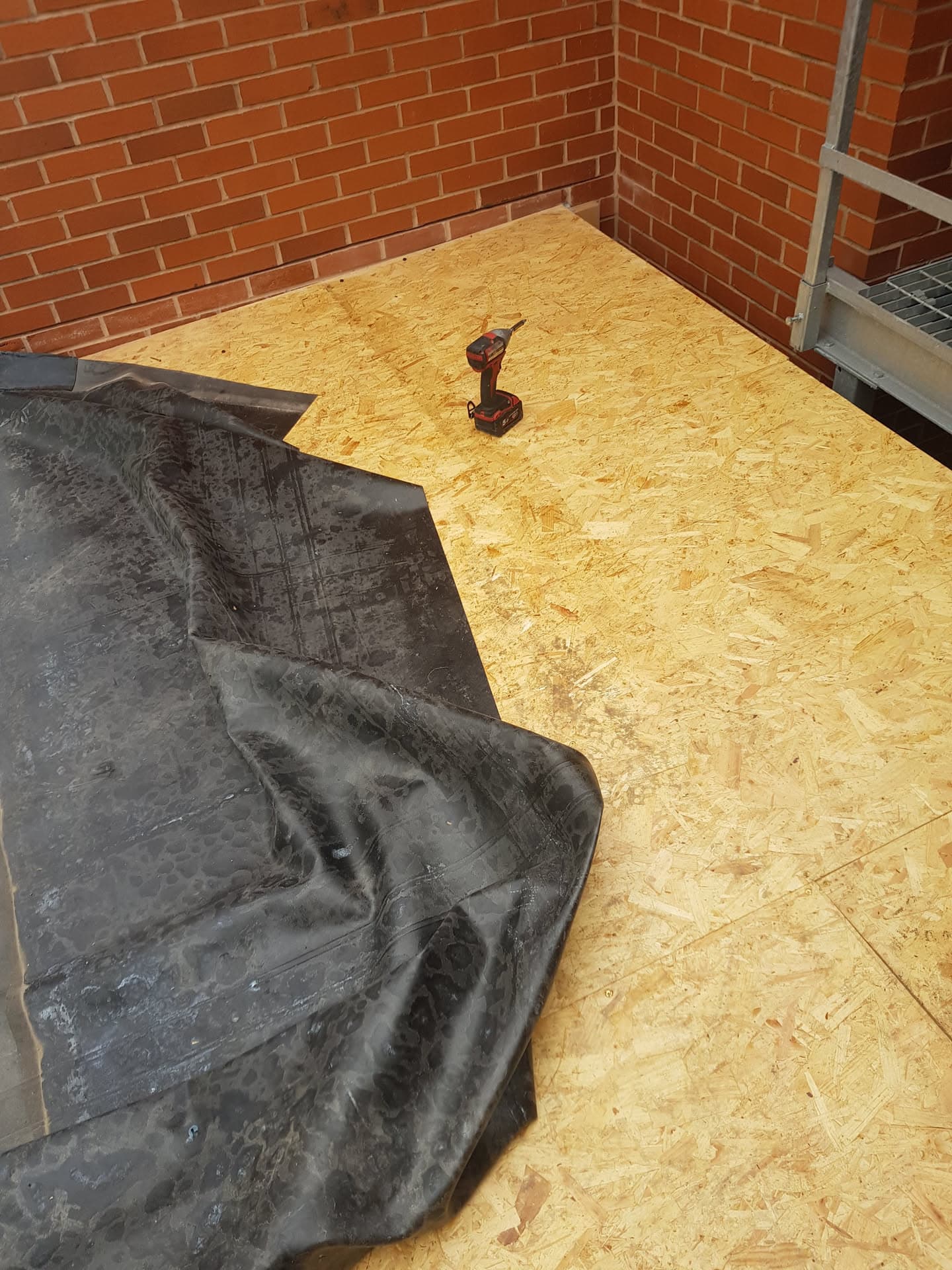 Flat roof with OSB boarding and EPDM rubber membrane being installed