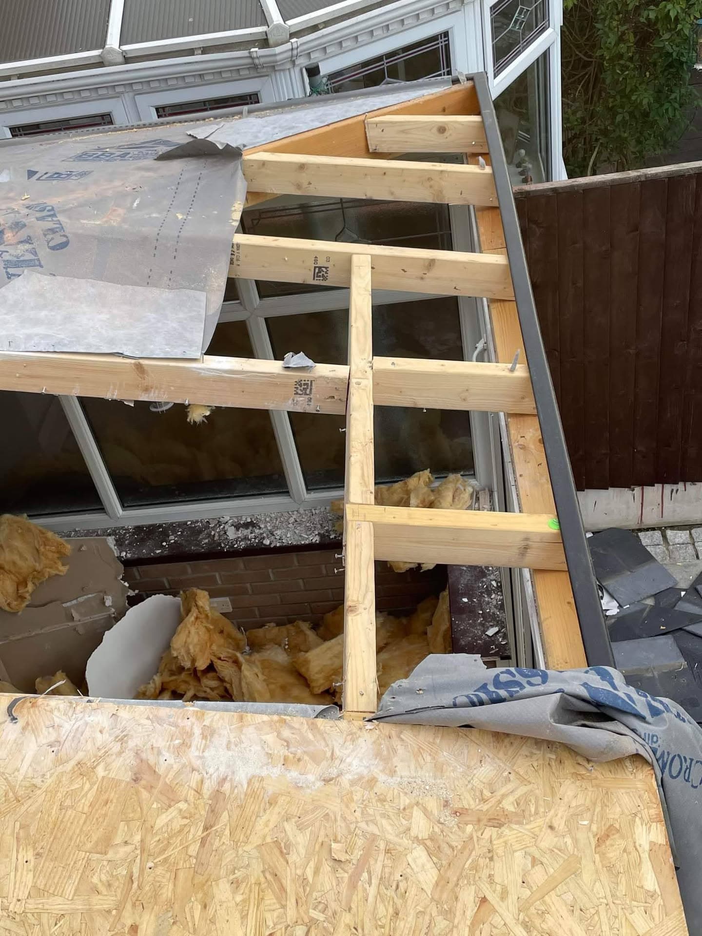 Flat roof construction in progress with timber framework and membrane underlay