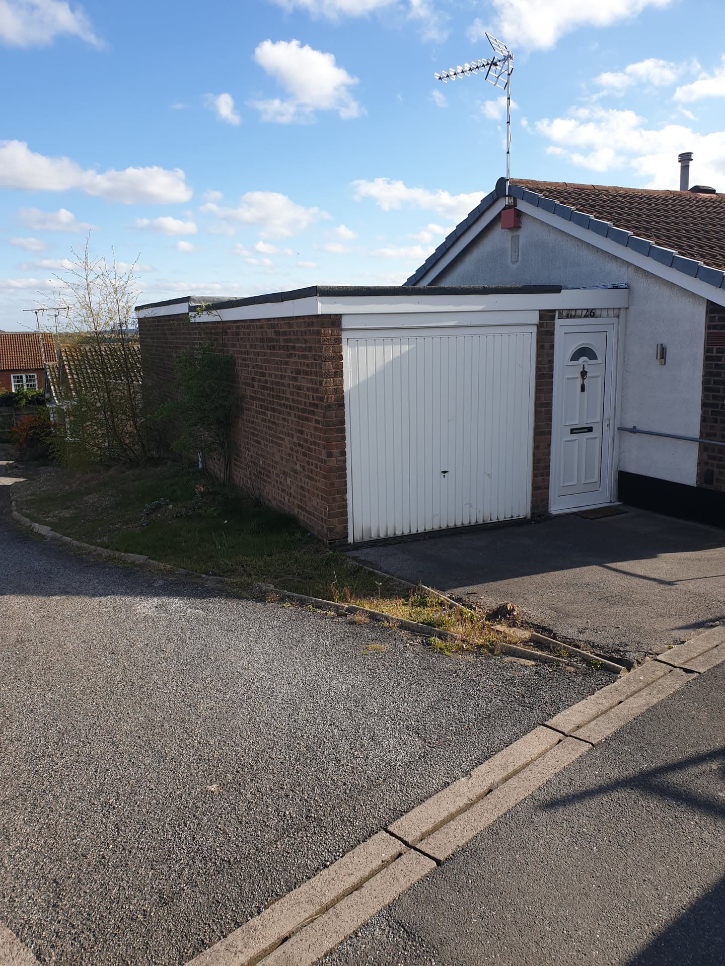 Flat roof installation on brick garage with white fascia trim