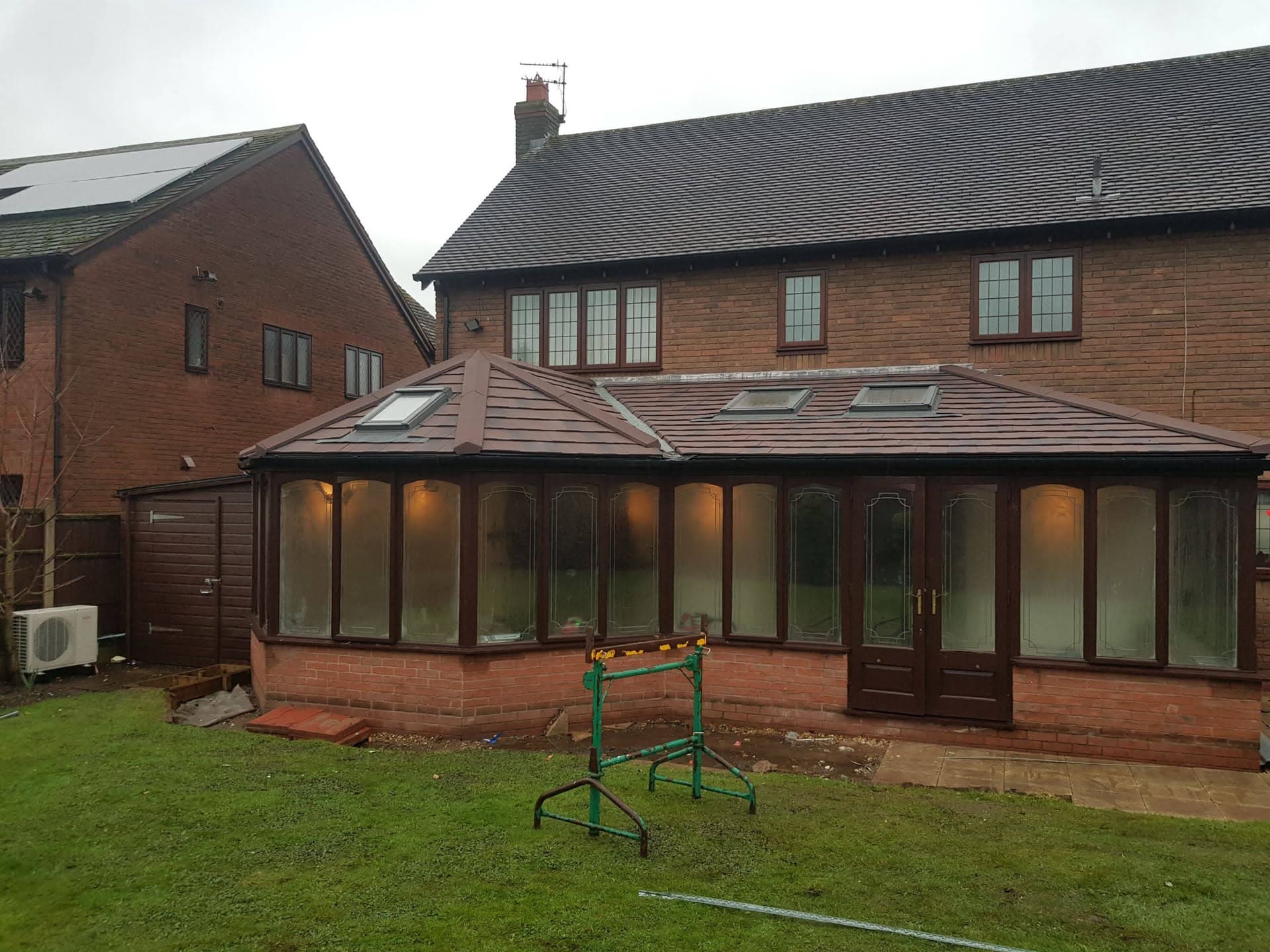Brown tiled conservatory roof with roof windows on brick-built extension