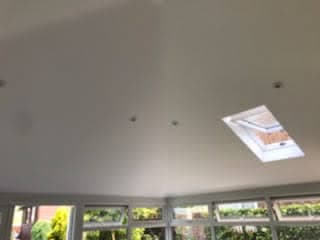 White conservatory ceiling with rectangular roof window installed