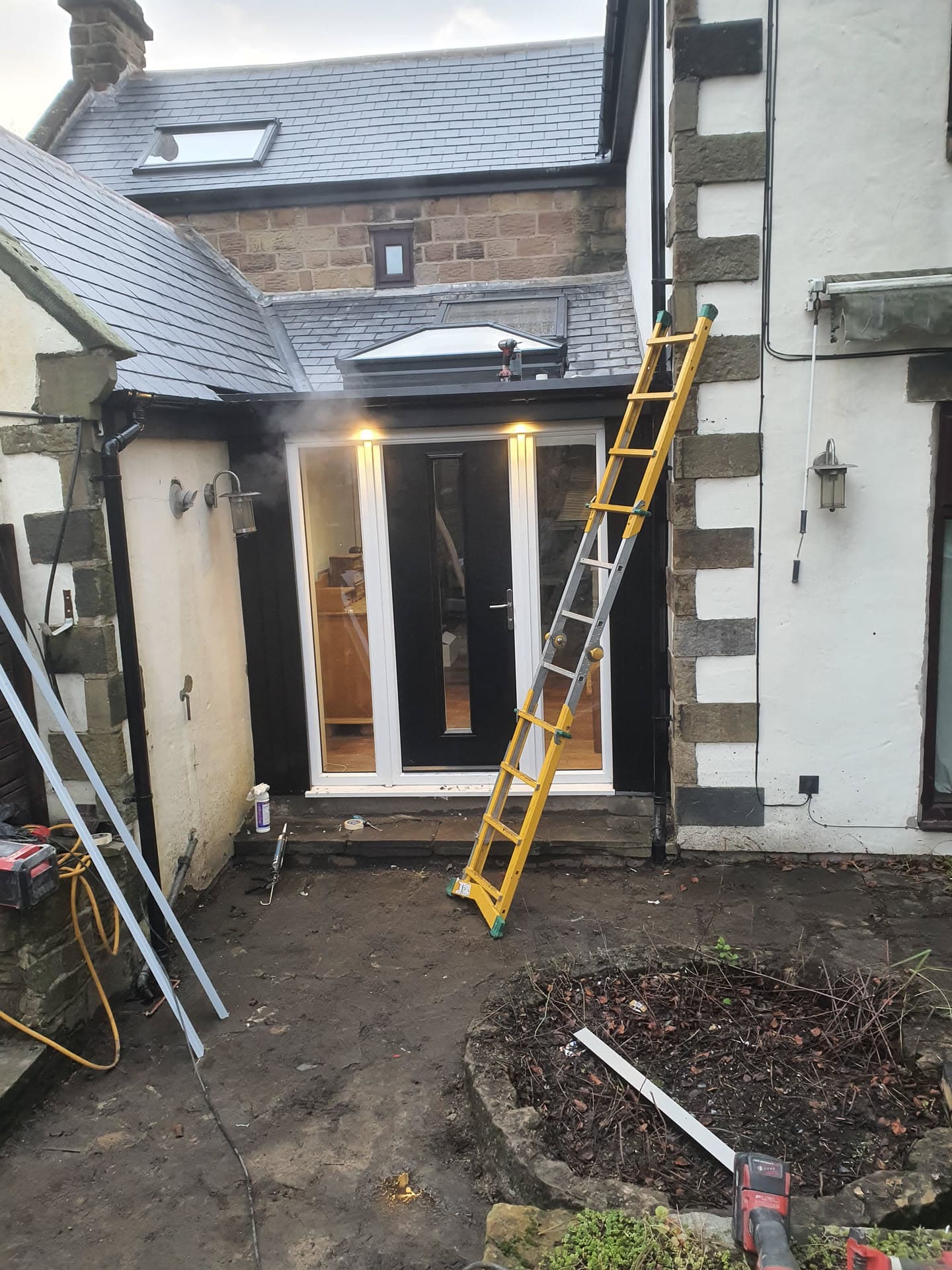 Grey slate pitched roof with velux window above rear extension entrance