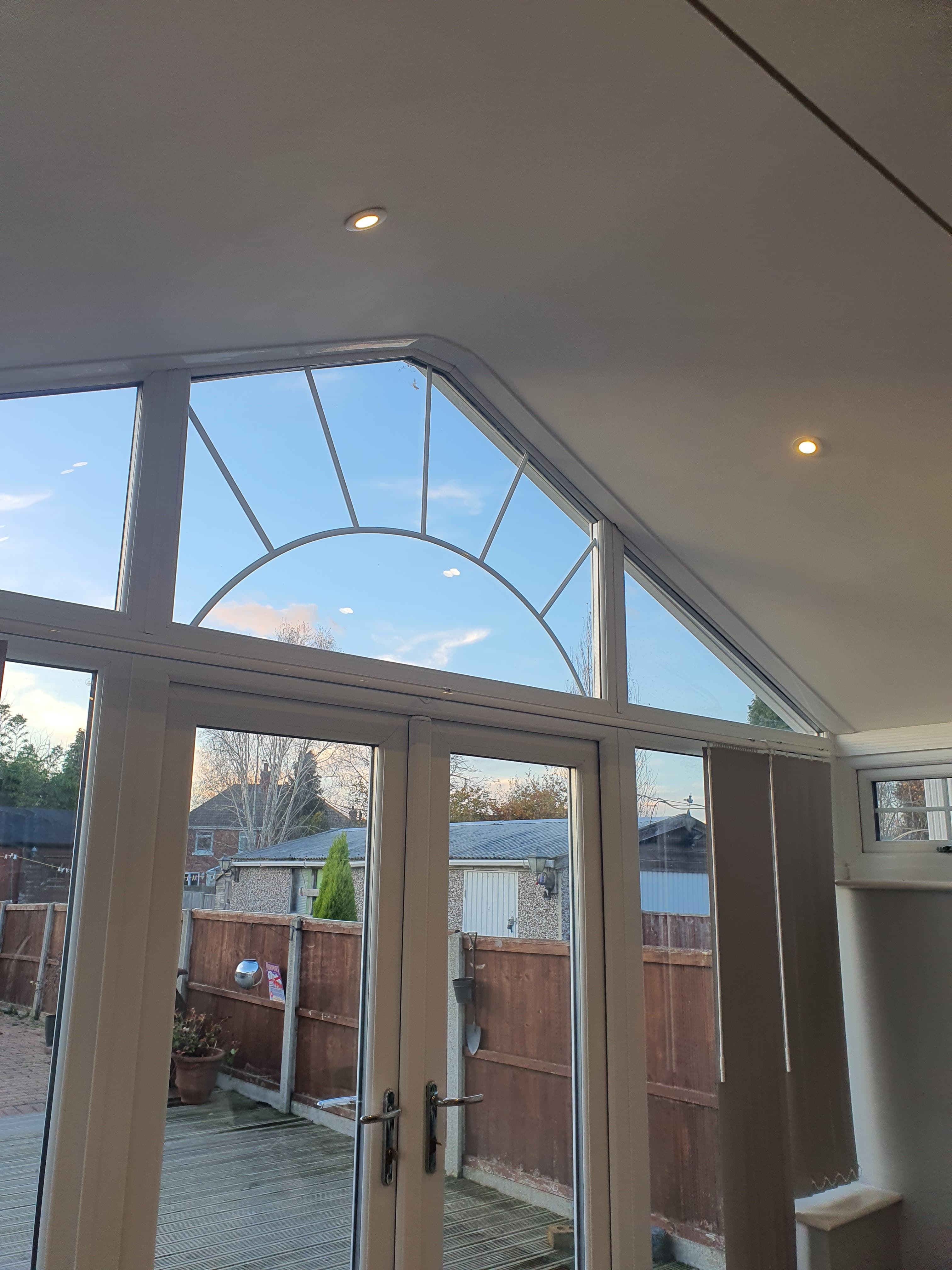 White conservatory roof with glazed panels and integrated spotlights viewed from inside