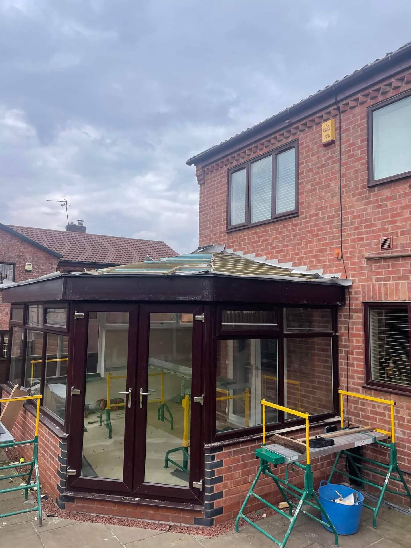 Conservatory with new flat roof installation on brick house