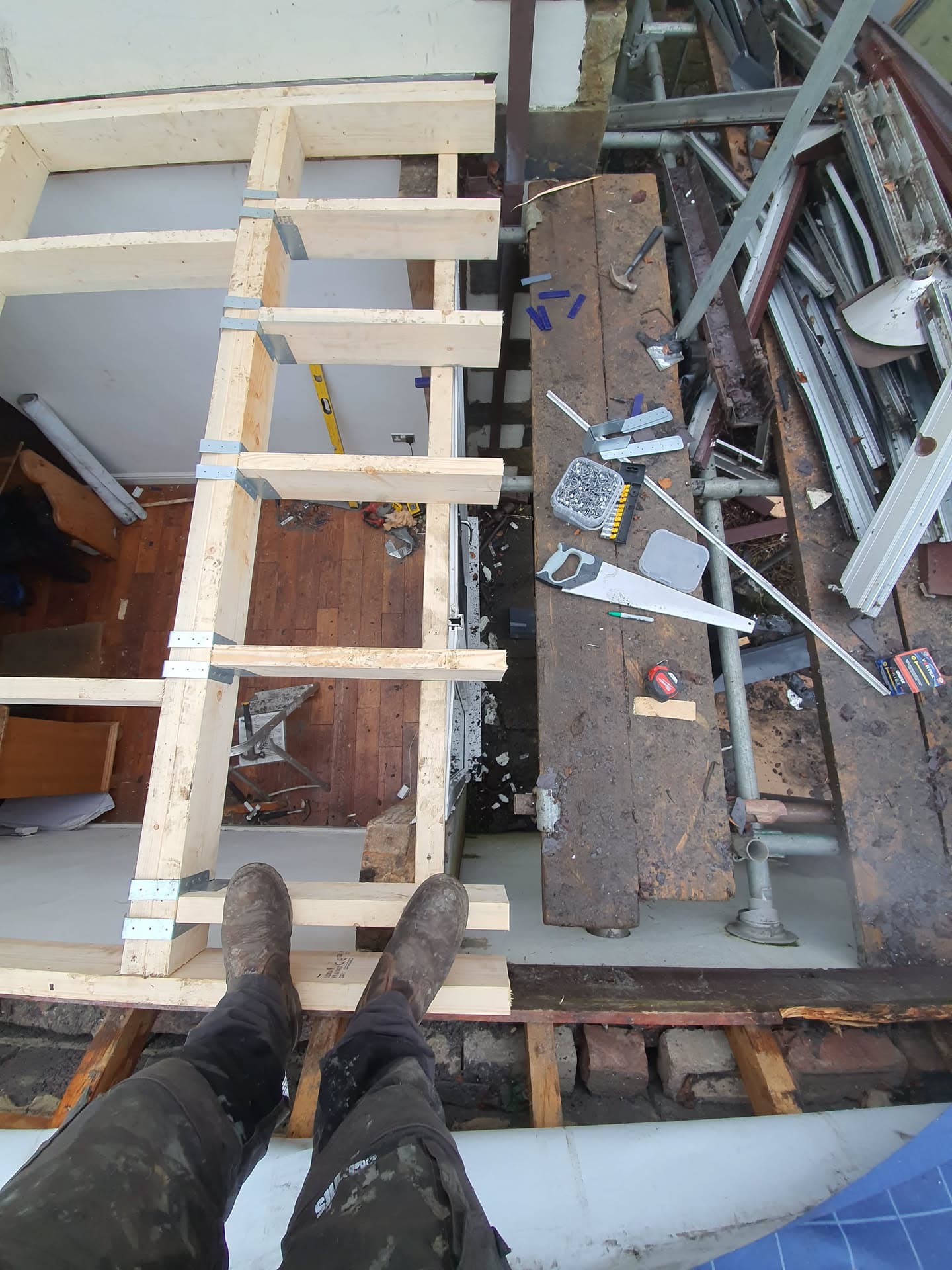 Overhead view of flat roof construction with timber joists and scaffolding boards