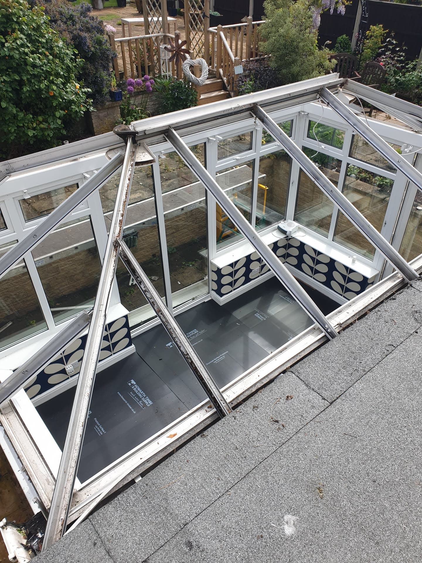 White uPVC conservatory roof frame with glazed panels during installation on flat roof