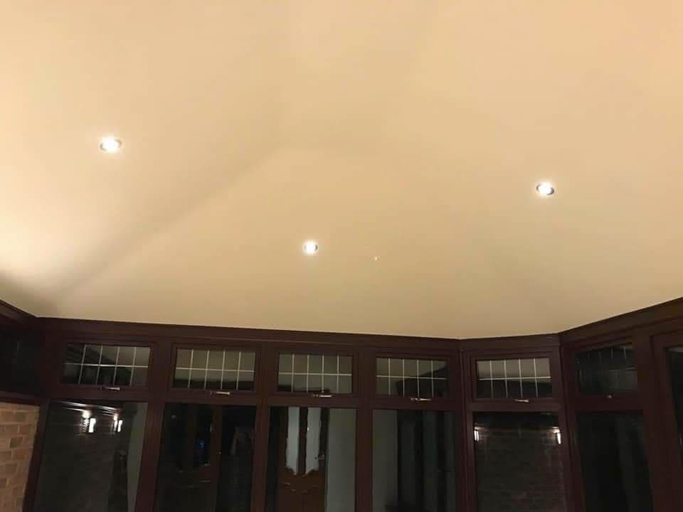 Cream conservatory roof with recessed spotlights and dark wood window frames