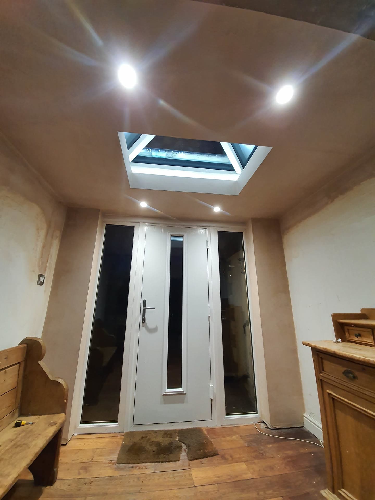 Interior view of flat roof skylight with white frame installed in plastered ceiling