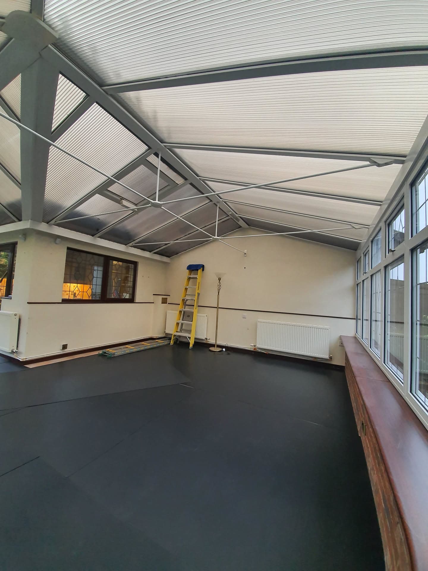 Interior view of conservatory with polycarbonate roof panels and grey aluminium framework